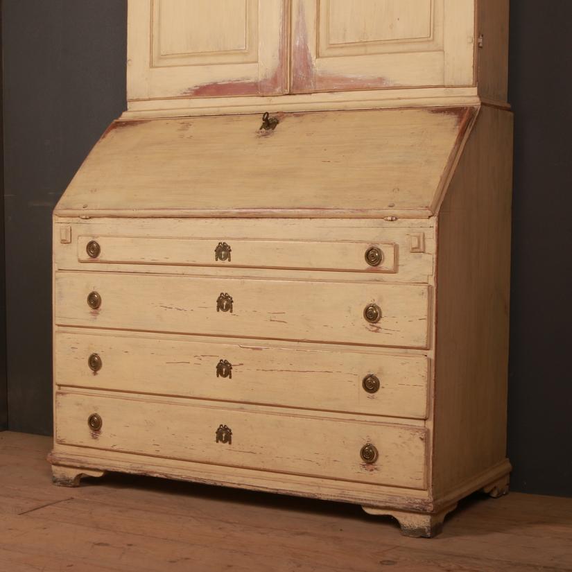 Early 19th century Swedish painted bureau. Top cabinet has two paneled doors below a carved arched cornice. Internal shelf depth of 7