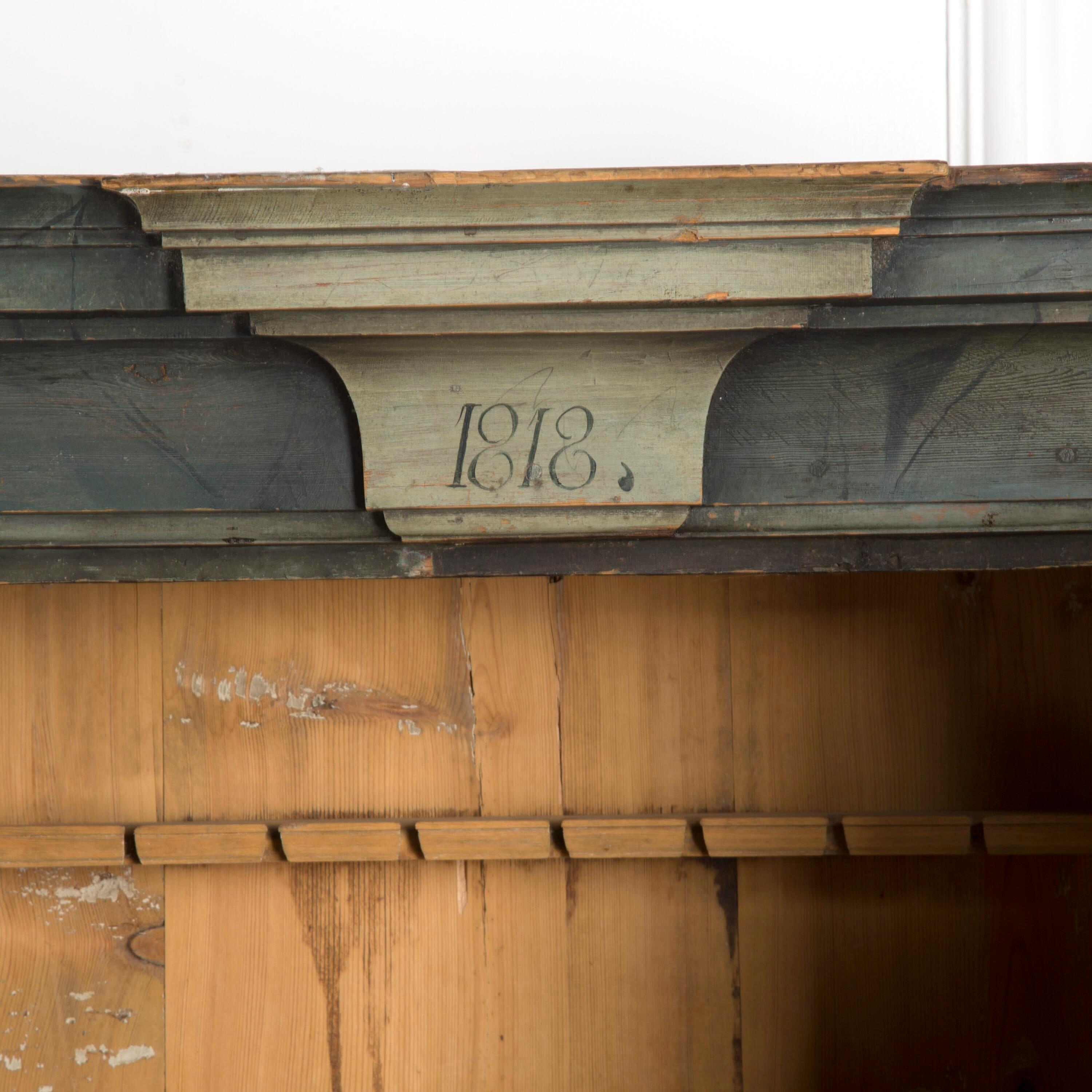 A Swedish painted wall cupboard with 2 doors and shelves. Dated 1818.