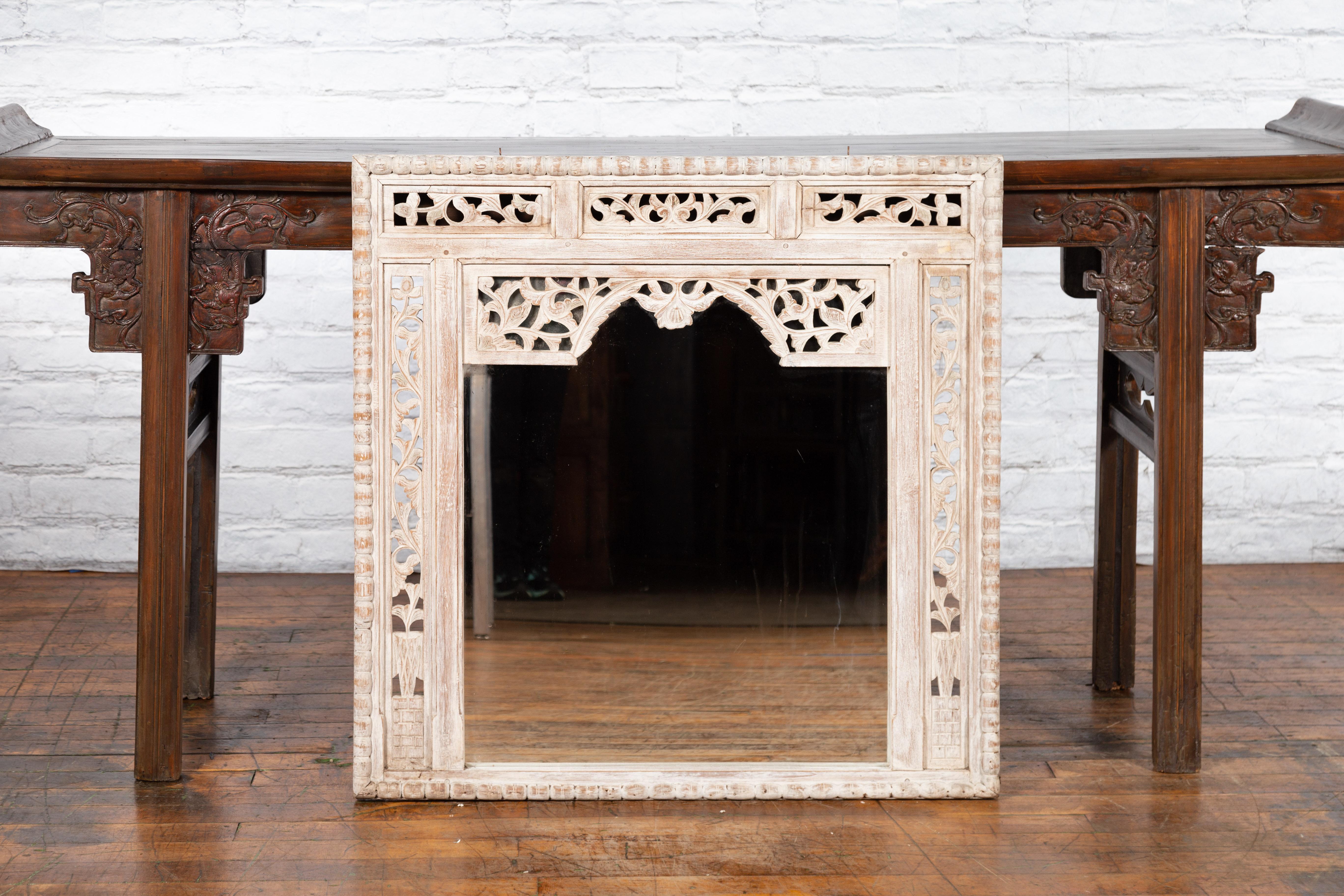 An antique painted Thai mirror from the 19th century, with hand-carved floral décor. Created in Thailand during the 19th century, this painted mirror features a rectangular silhouette perfectly adorned with carved foliage motifs. Accented with