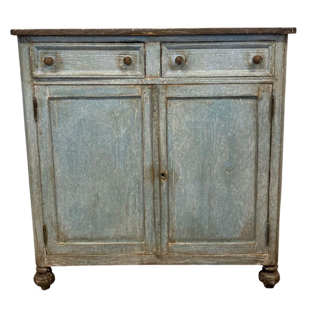 Credenza hand-crafted in Italy in the early 1800s using pine and pegged construction. The credenza shows a two over two composition with two drawers over two doors. The fronts of both drawers and doors are flat, composed by an inset panel framed by