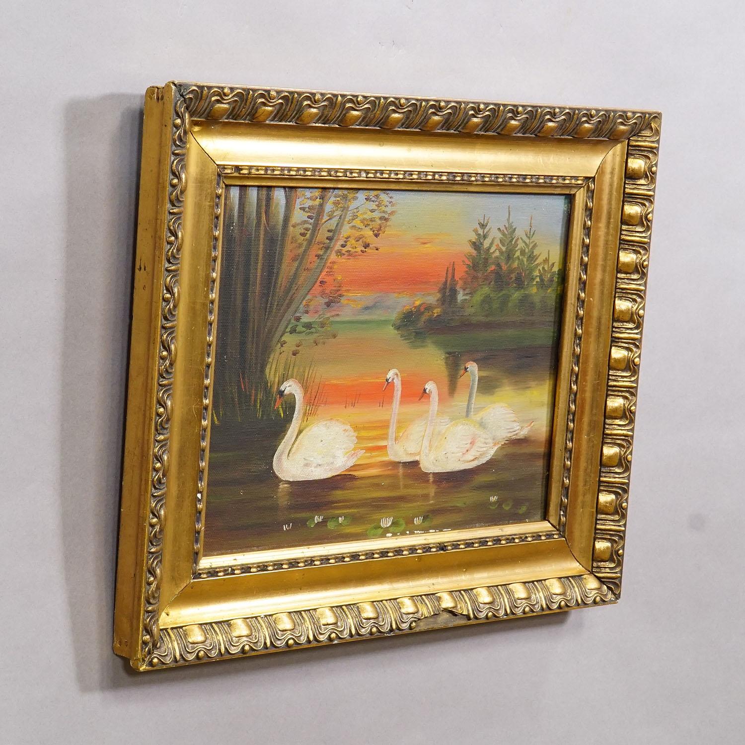 19th Century Painting with Swans on a Lake at Sunset

The antique oil painting, presented in a gilded wooden frame, was created on canvas in the late 19th century. It portrays a peaceful sunset scene, with a group of swans gliding across still