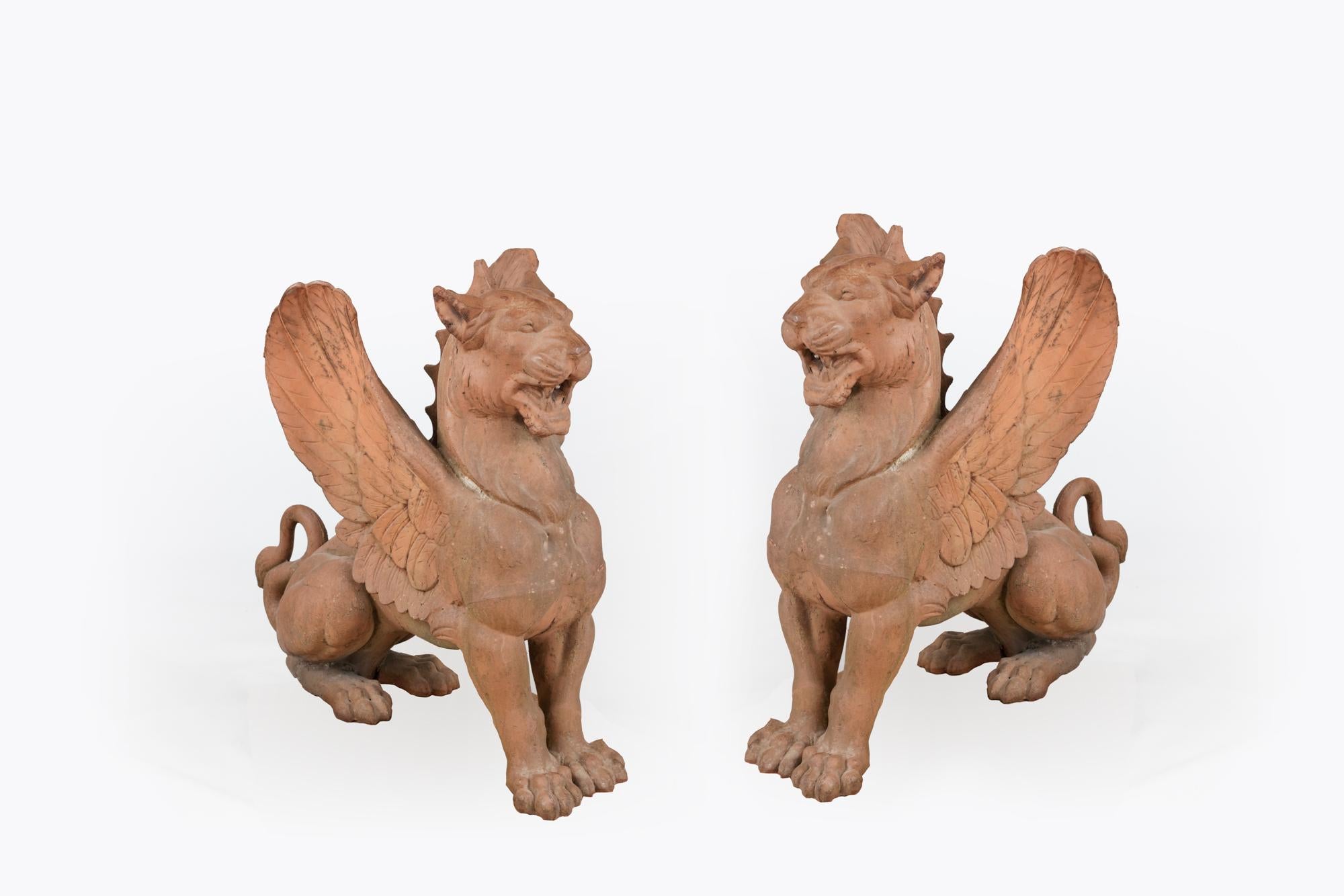 Pair 19th century cast iron garden griffins in the seated position. The griffin is a mythical beast having the head, wings and claws of an eagle and the body of a lion, whose combined symbolism represents both courage and watchfulness. Giving the