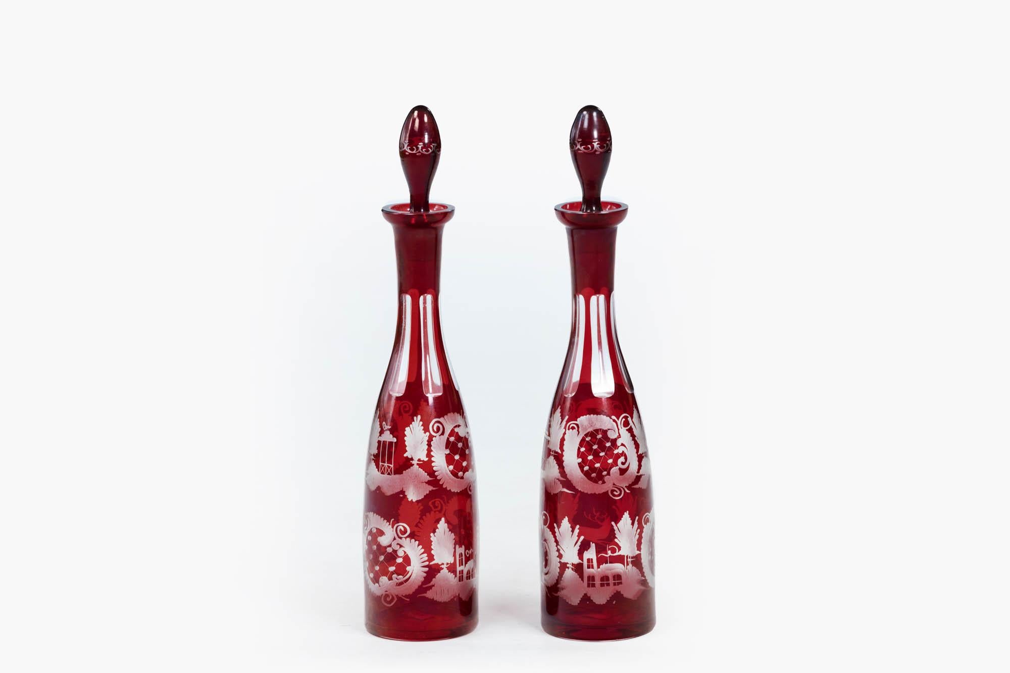 19th Century pair Egermann Bohemian Czech ruby glazed and engraved glass decanters, of tall slender form, cut to clear, complete with original firm fitting stoppers. The pair feature Egermann’s popular deer and castle theme decoration.