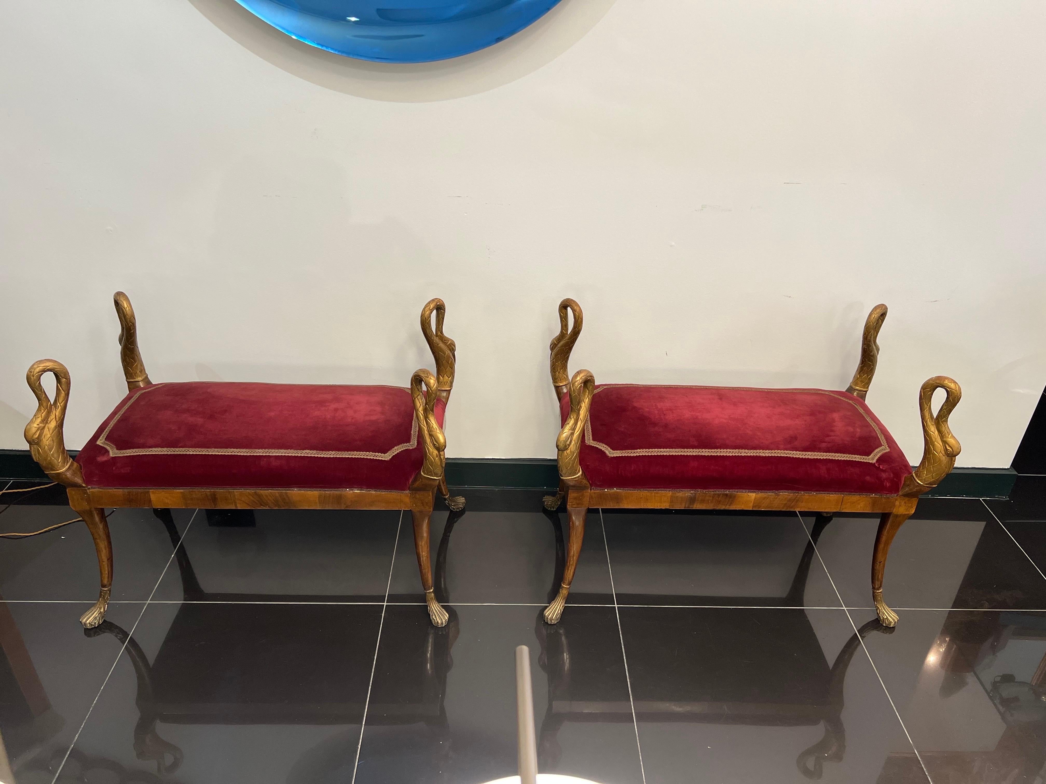 A rare pair of 19th century Italian empire swan benches in cherrywood veneer with hand carved and gilded swan motifs in original velvet fabric with gold braided border.

Dimensions: H:71cm W:90cm D:43cm Seat height:47cm