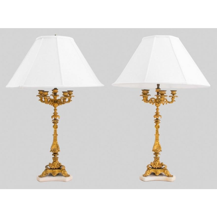 Mettez en valeur votre espace de vie avec cette exceptionnelle paire de lampes de table candélabres en bronze doré de style Napoléon III du XIXe siècle, chacune ornée d'une base en marbre de forme géométrique. Non seulement ces lampes sont un régal