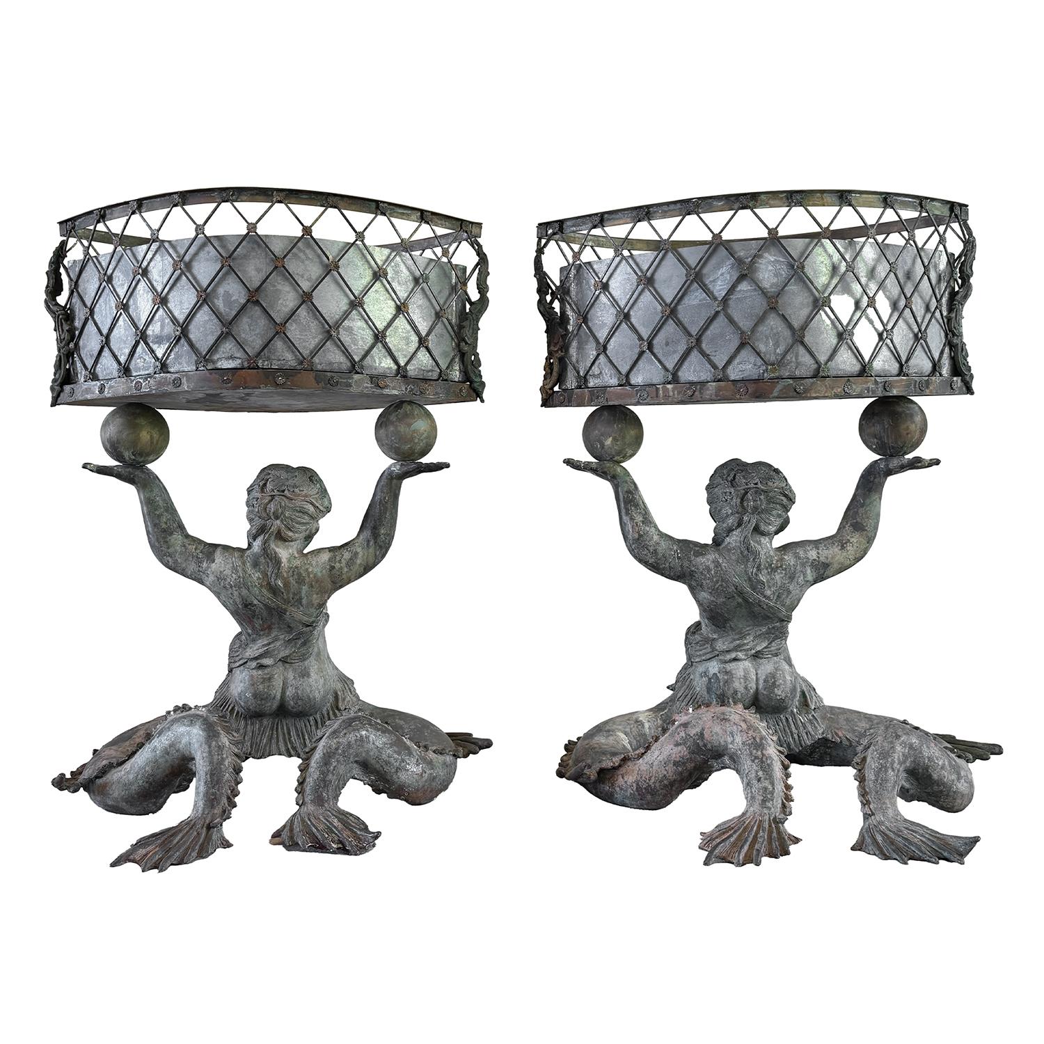 Coppia decorativa e antica di jardinières in bronzo francese del XIX secolo, ciascuno sostenuto da una figura di putto seduto che poggia su una base stilizzata a forma di conchiglia, in buone condizioni. Le fioriere sono caratterizzate da ampi cesti