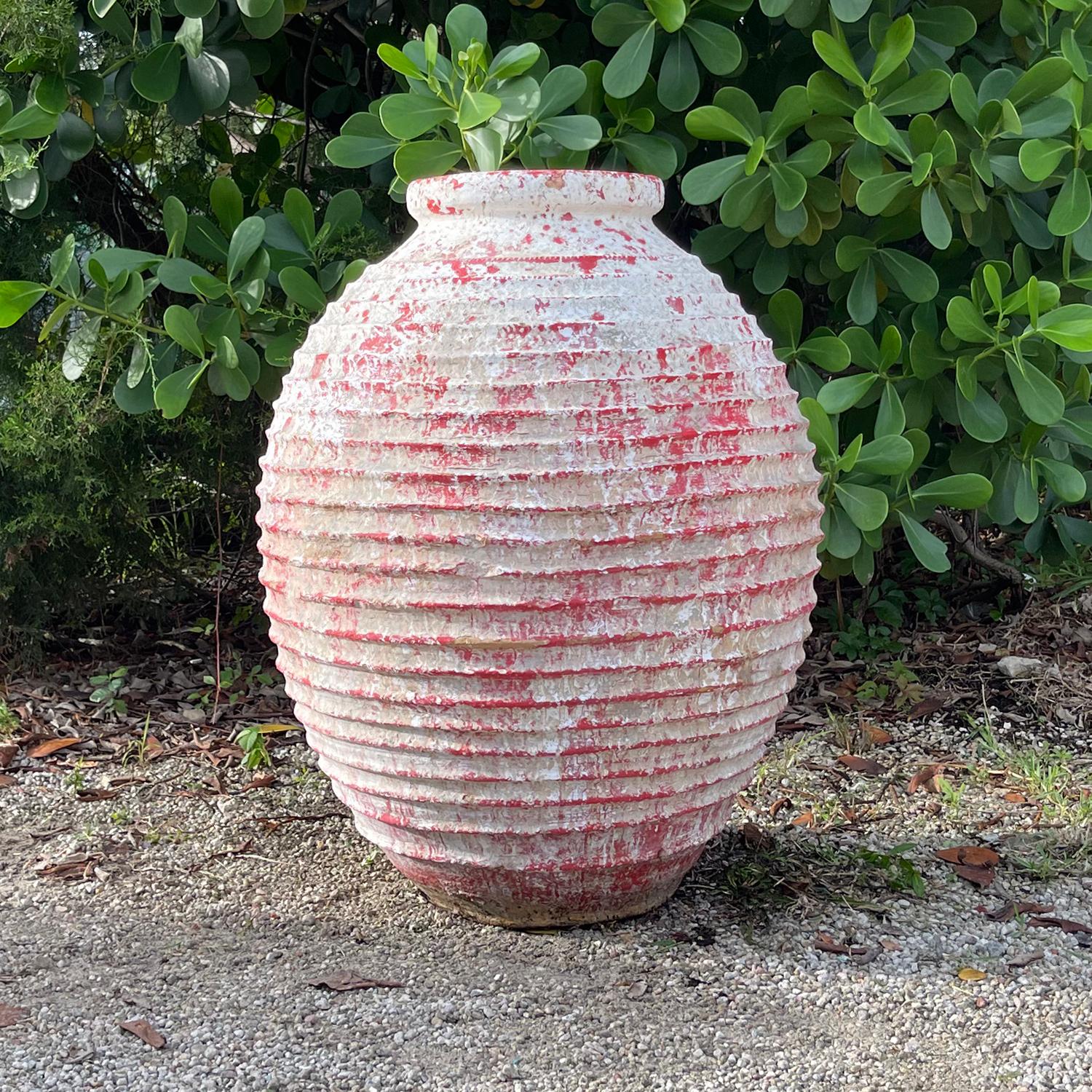 Questa coppia di vasi per olive del Peloponneso greco, realizzati a mano nel XIX secolo, presenta la tipica decorazione a coste Nekuma sul corpetto rotondo in terracotta. La superficie irregolare presenta un lavaggio bianco patinato abbinato a