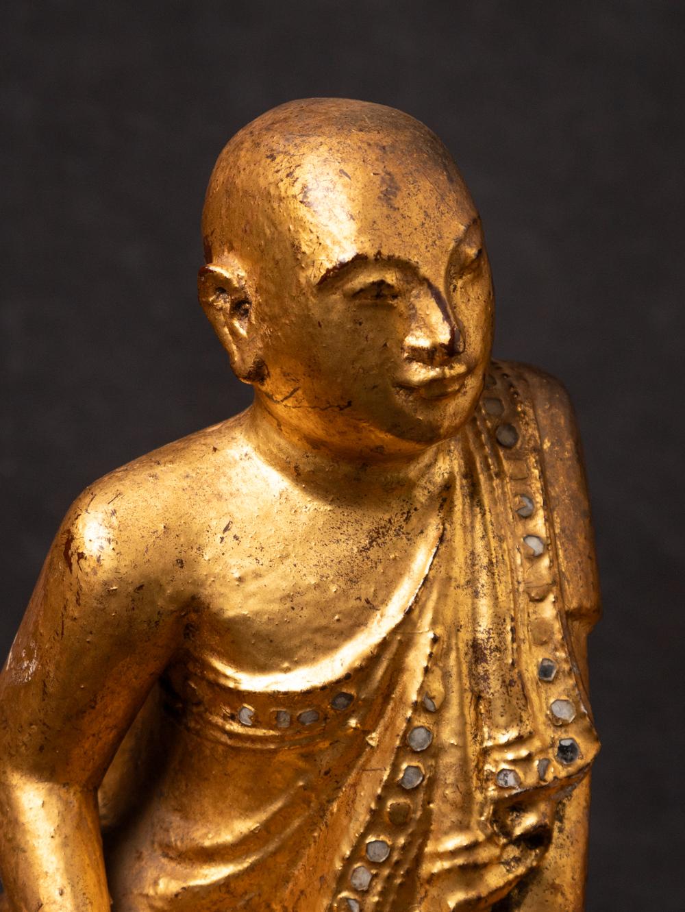 The pair of antique wooden Burmese Monk statues is a remarkable and spiritually significant artifact originating from Burma. Crafted from wood and gilded with 24-karat gold, each statue stands at 22.5 cm in height and measures 21.7 cm in width and