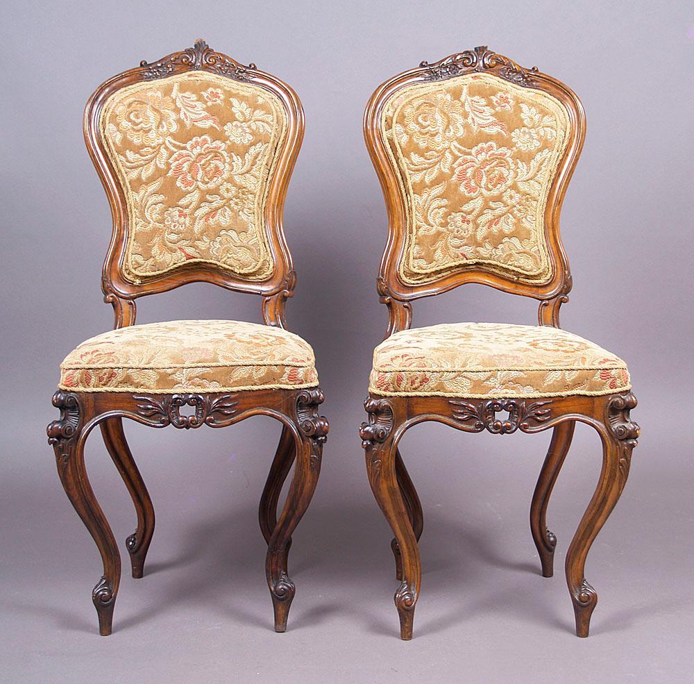 19th century pair of Baroque walnut chairs,
upholstered on the seat and backrest, supported on four legs, front and rear sigmoid. The front rail and legs are decorated with carvings in the form of leaves and shells. Backrest with a curved structure