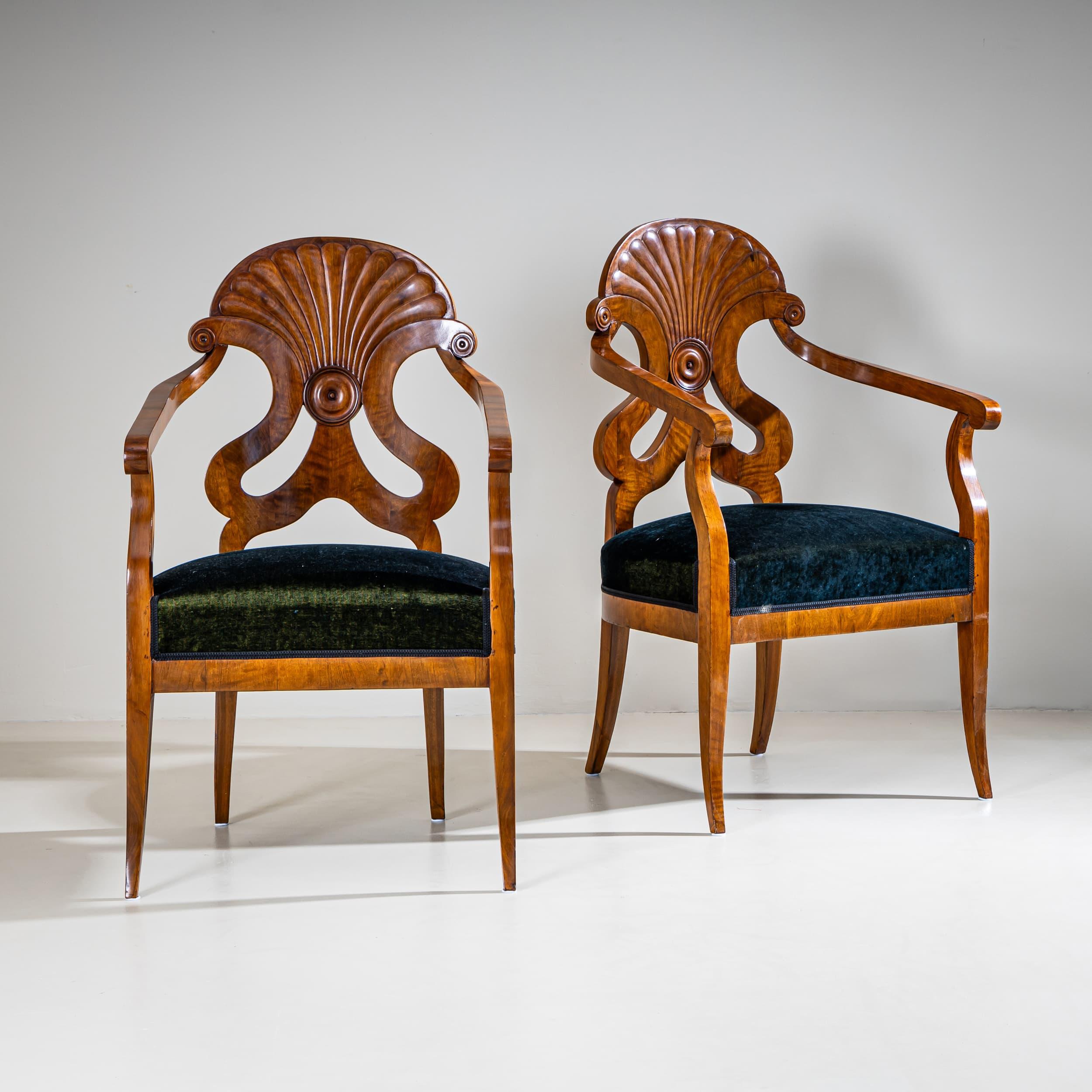 Paar Sessel aus Nussbaumholz mit fächerförmigen, aufwändig gearbeiteten Rückenlehnen und elegant verjüngten Beinen. Die Stühle sind restauriert und neu gepolstert worden. Der Samtstoff schimmert in Grün- und Blautönen.
