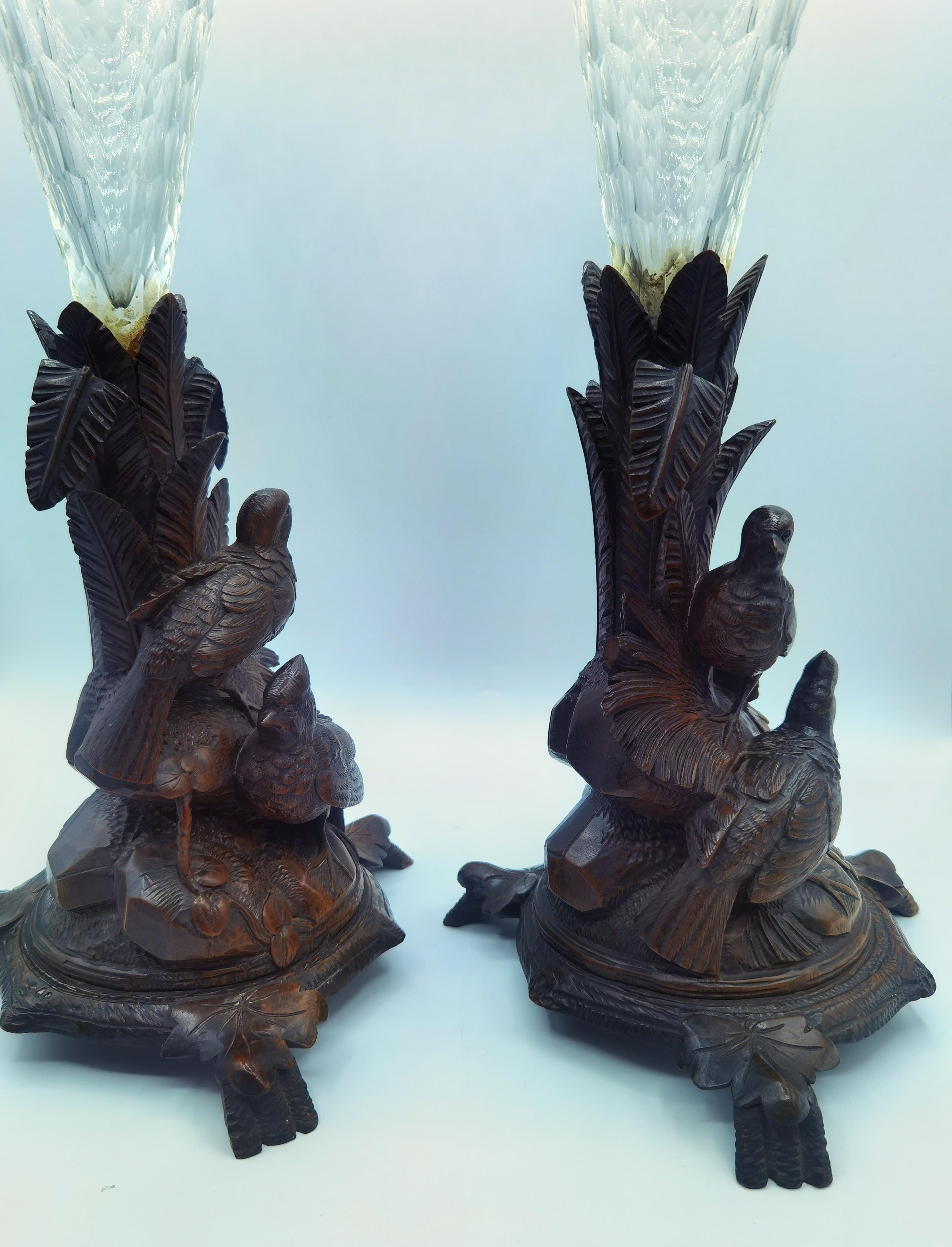 Pair of 19th century large hand-carved centerpieces in wood. The vases are showing a pair of birds sitting opposite side hand-carved with leaves. The centerpieces are in two parts. The crystal glass for flower decoration are hand-engraved and can be