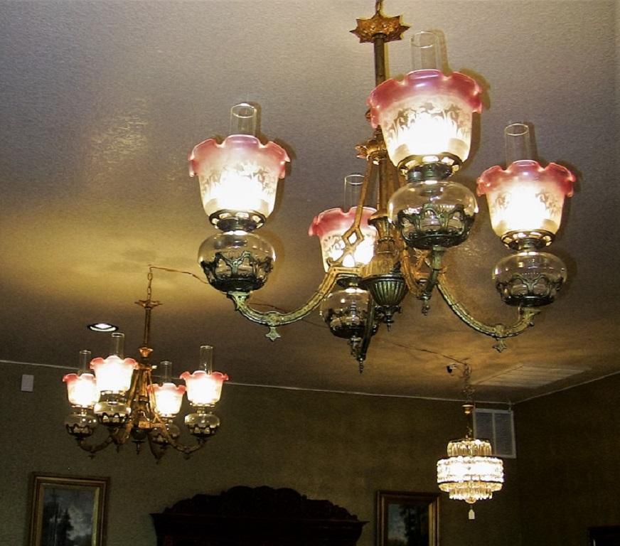 Extremely rare, fine and quality matching pair of Bradley & Hubbard four-arm chandeliers from circa 1885.

These chandeliers were originally kerosene lamps and were converted in the early 20th century to electricity.

Both chandeliers are most