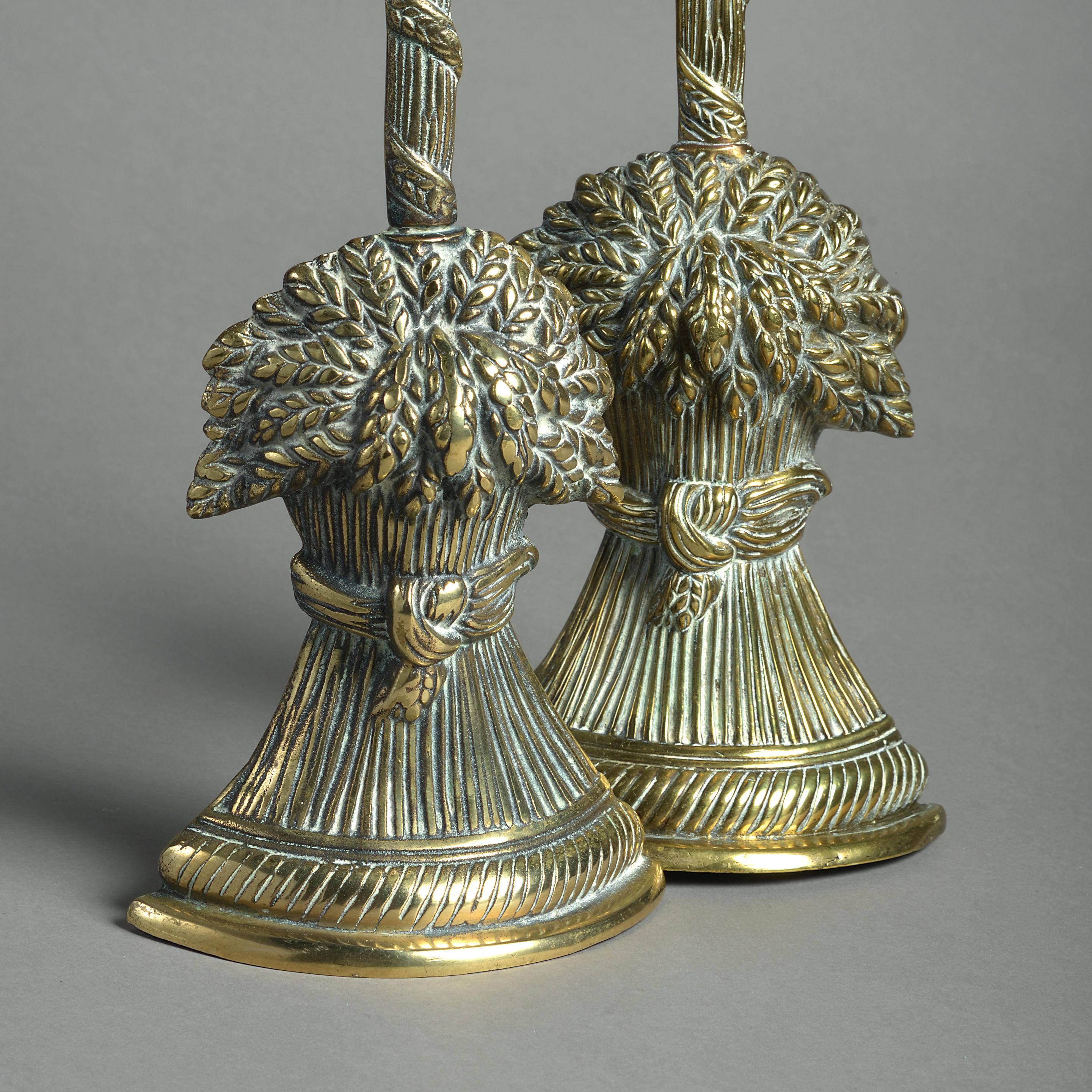 A late 19th century pair of brass doorstops, each having a carrying handle and weight in the form of a wheatsheaf.