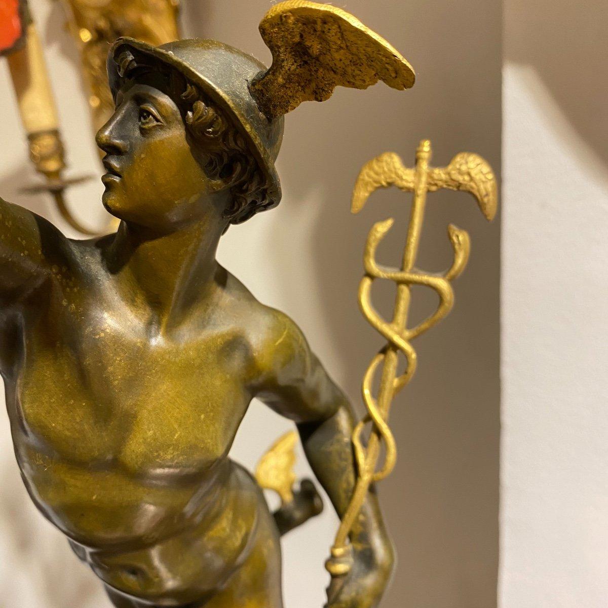 Ces impressionnants chandeliers en bronze de 78 cm de haut, représentant les figures mythologiques dorées et finement patinées d'Hermès et de Diane, reposent gracieusement sur des bases rondes et cannelées, ornées d'un anneau en bronze doré. Chaque