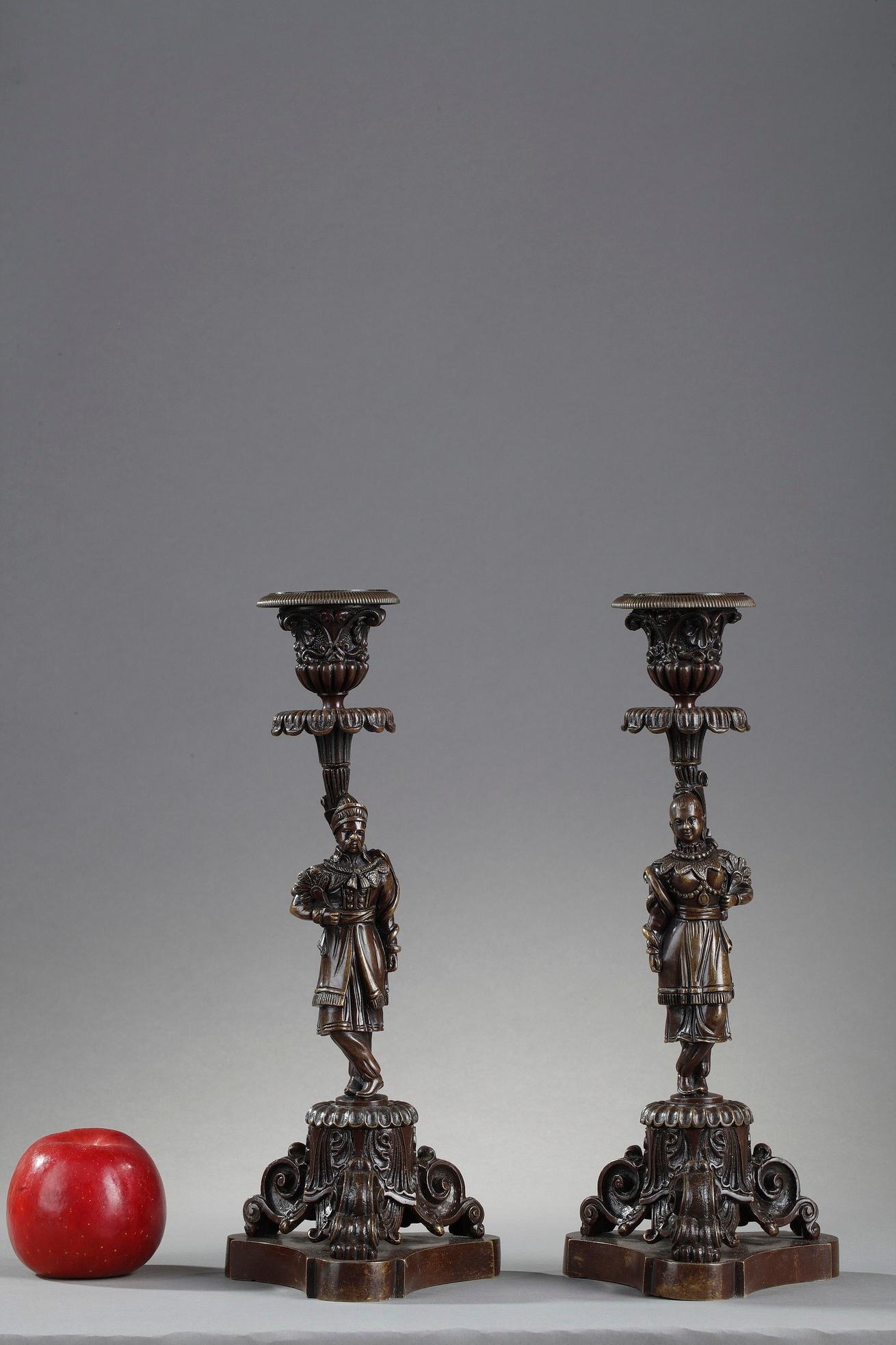 Kerzenhalter aus patinierter Bronze vom Ende des 19. Jahrhunderts, der Stiel mit chinesischen Motiven verziert. Der Mann und die Frau, elegant gekleidet, ruhen auf einem dreibeinigen Sockel. Der Sockel und die Tülle sind mit detaillierten Schnörkeln
