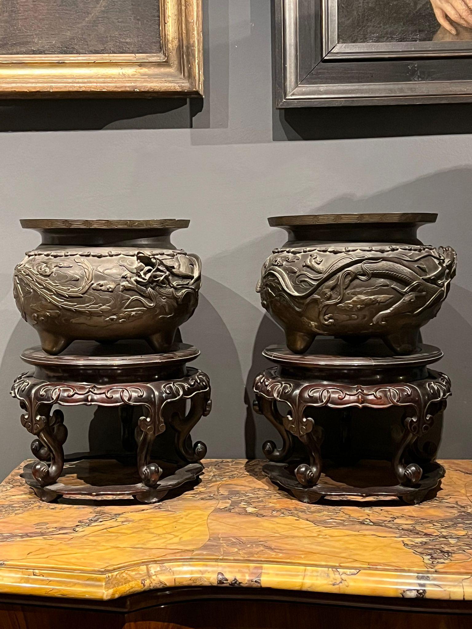 Beautiful pair of bronze vases depicting dragons and phoenixes. The two pedestals are in carved wood, from Japan, early 19th century.