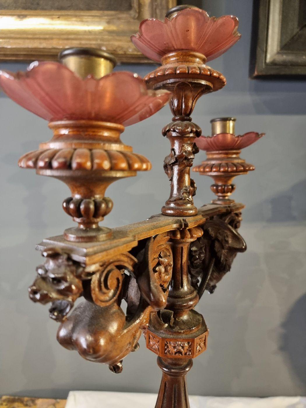 Beautiful pair of candlesticks with three lights, in finely carved wood with ivy and Grifi motifs. On the two bases there are eight carved heads, all different from each other. Comes from central Italy, and the period is late nineteenth century.