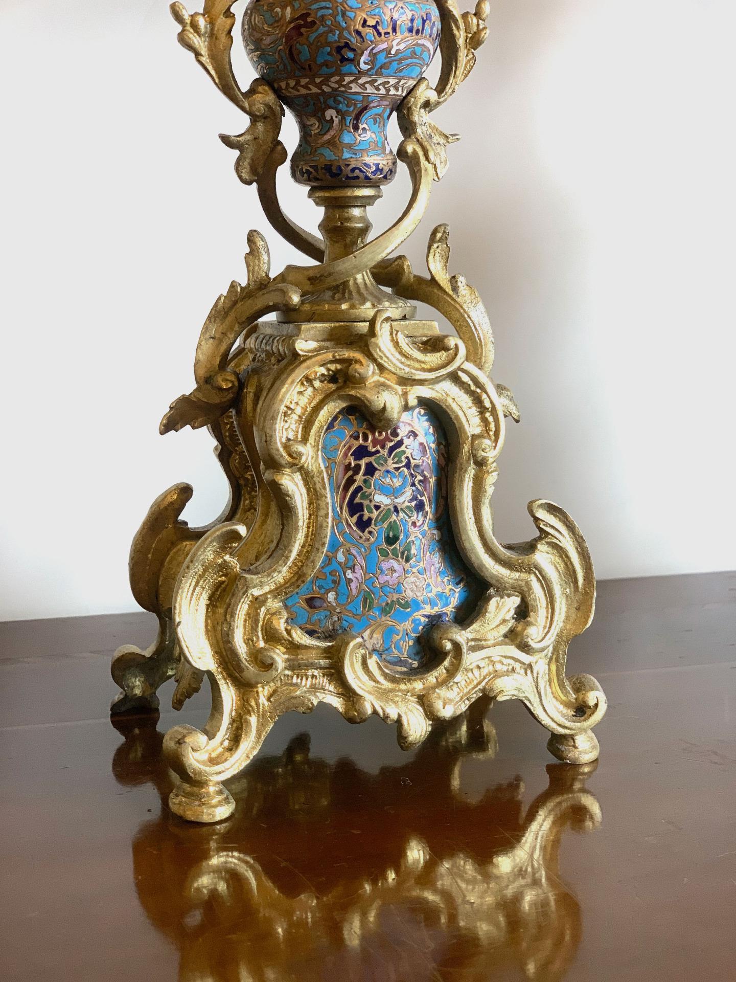 Elegant pair of gilded bronze candlesticks with leaf-like shapes and glassonnè enamel inserts. Typical French manufacture from the mid-1800s. The material used was produced in the East to complete objects with a clear European taste. The