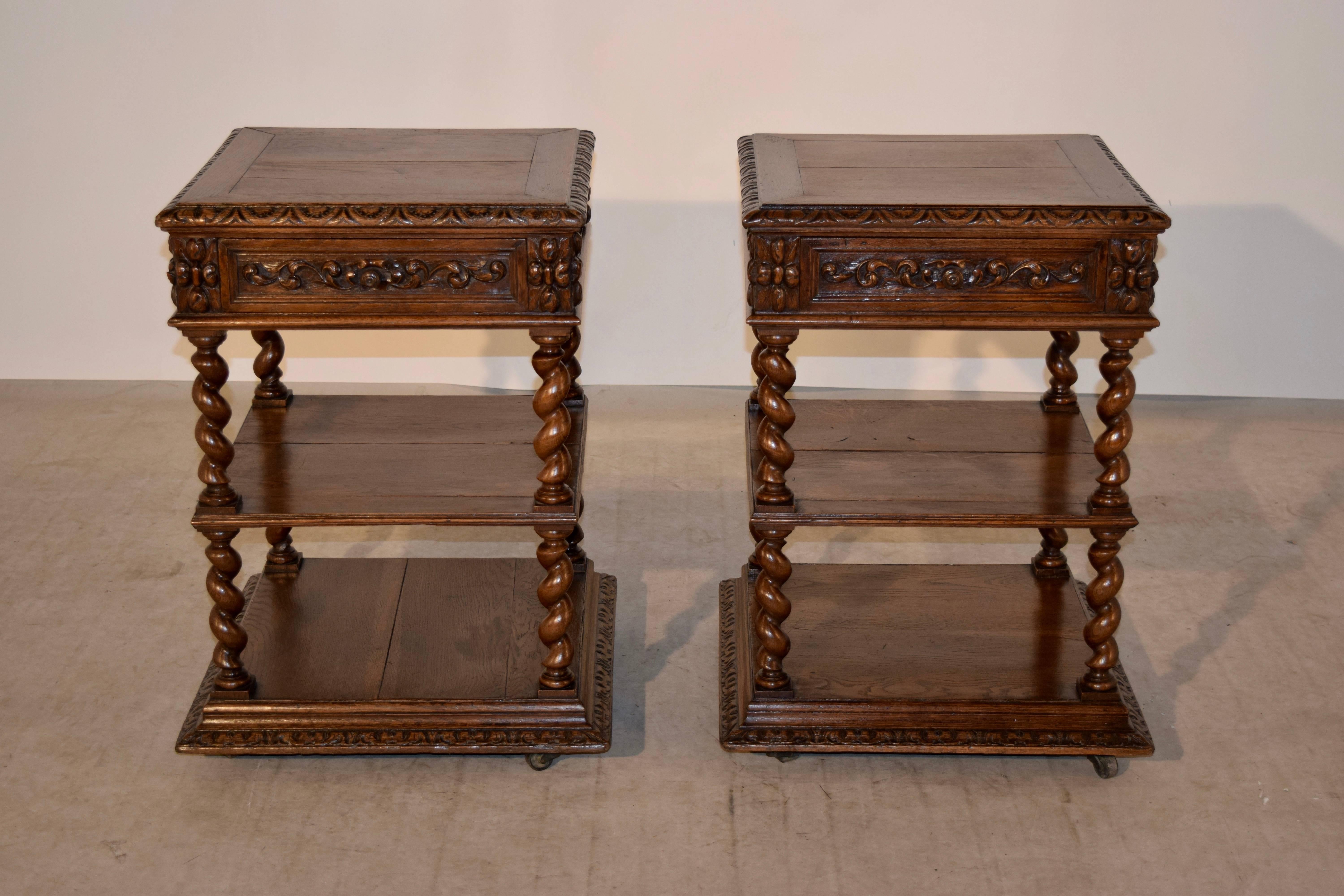 19th century pair of hand-carved oak side tables from France. The tops has bevelled and carved decorated edges following down to hand-carved panelled sides. The front side contains a single drawer, which is carved to match the side panels. There are