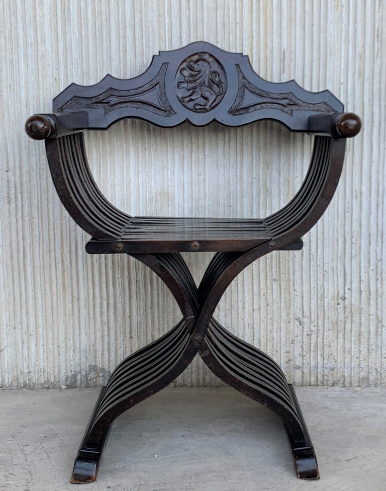 19th century carved walnut folding scissors Savonarola bench or settee featuring a lion shield in the back.

Typical of the Italian Renaissance with carved Florentine backs (no shows in the picture).
This pair created in the 19th century, most
