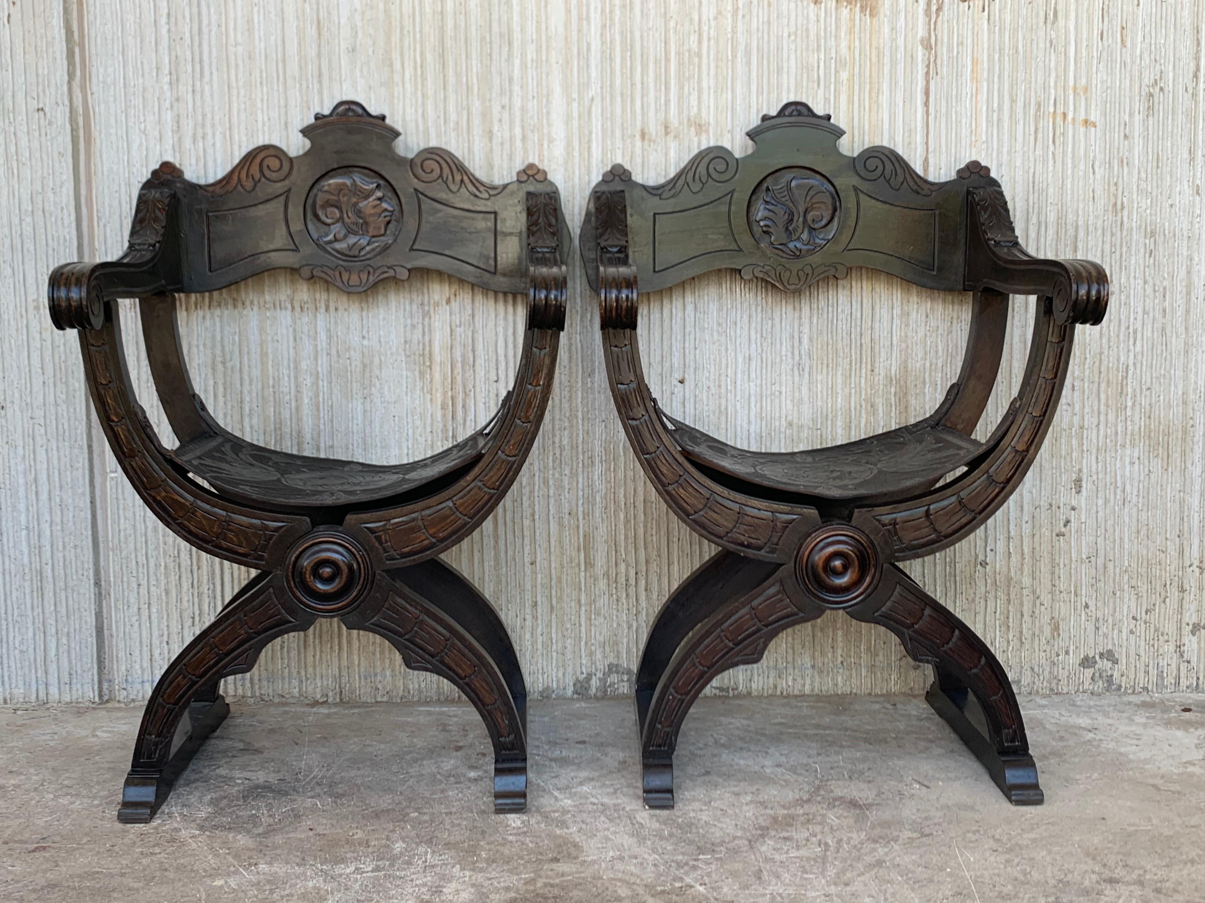 19th century Italian hand carved walnut Savonarolas chairs, circa 1880. Having wonderfully carved frame with scrolling arms, aged black tooled leather seat and back, accented with brass rosettes and exhibiting a lovely patina. In perfect
