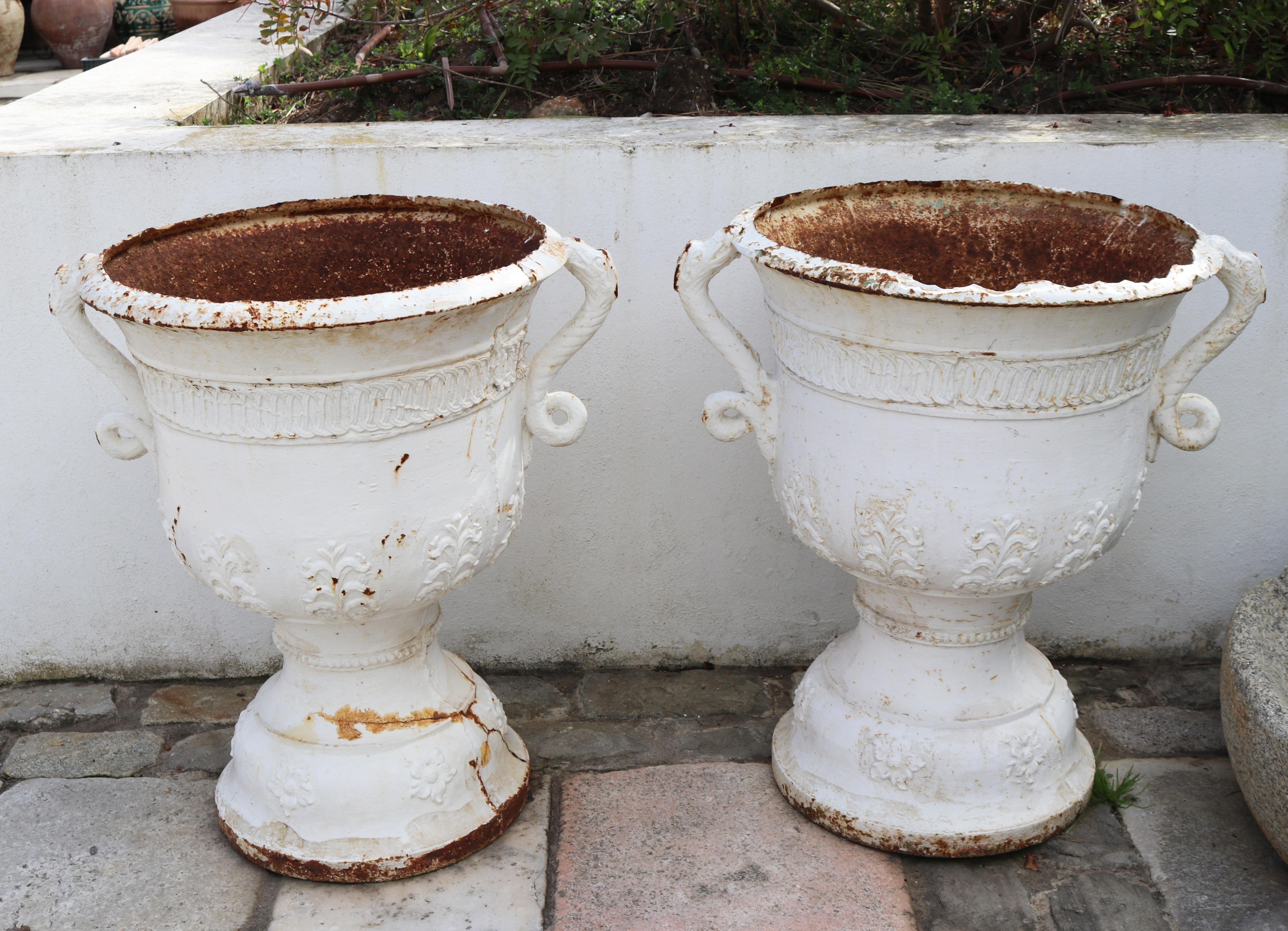 19th century pair of cast iron French white garden urns with dragon handles and geometrical and flower relief decorations.