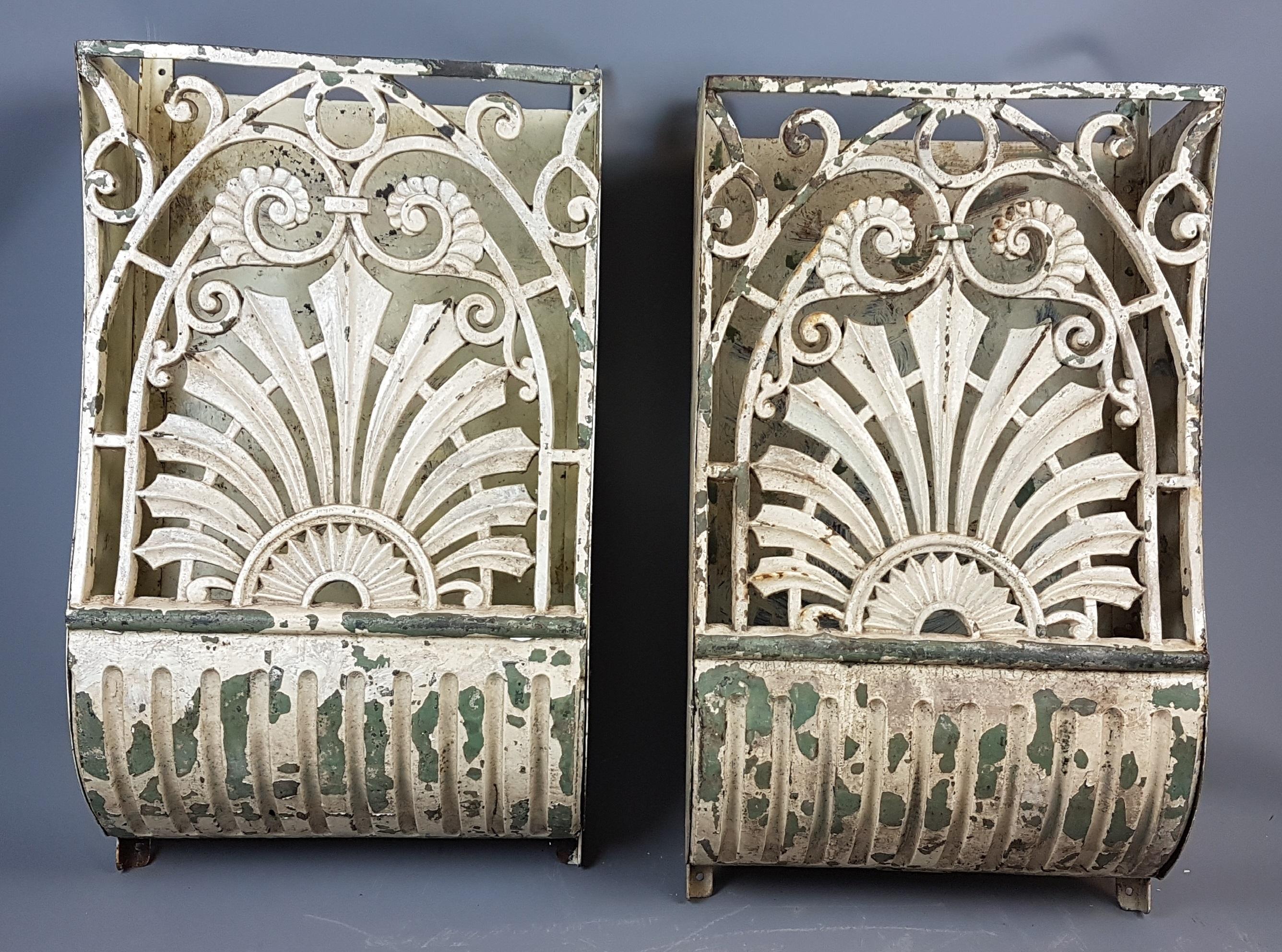 This is a great and very decorative pair of 19th century cast iron wall-mounted pockets that are perfect for unique consoles with lighting inside.

They have layers of old paint that has given them a desirable appearance with the base layer being