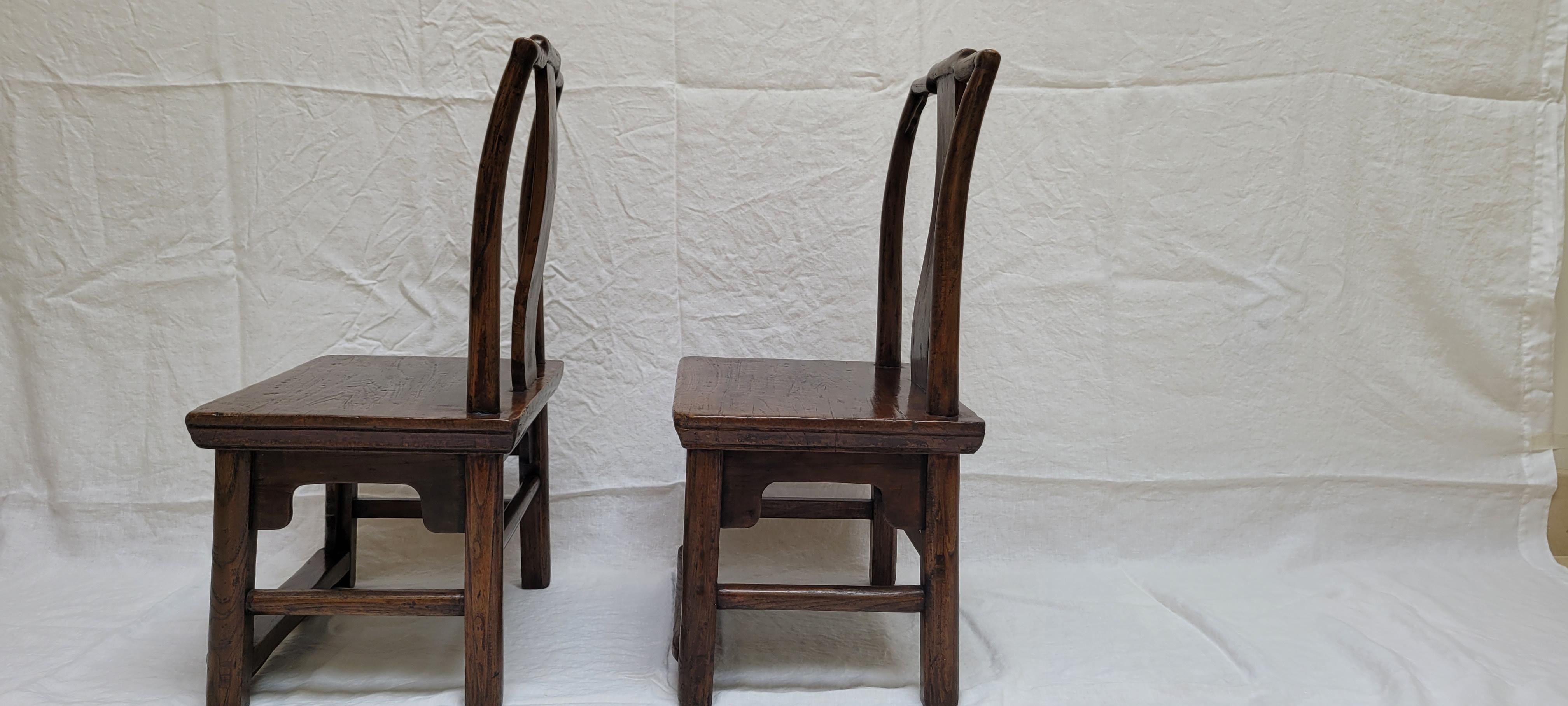 This pair of children’s chairs has a back frame in the Southern Official hat style. The seat is made of a solid plank of wood. The aprons are done in the traditional Jin style with the trailing plant motif as decoration. The chairs were originally