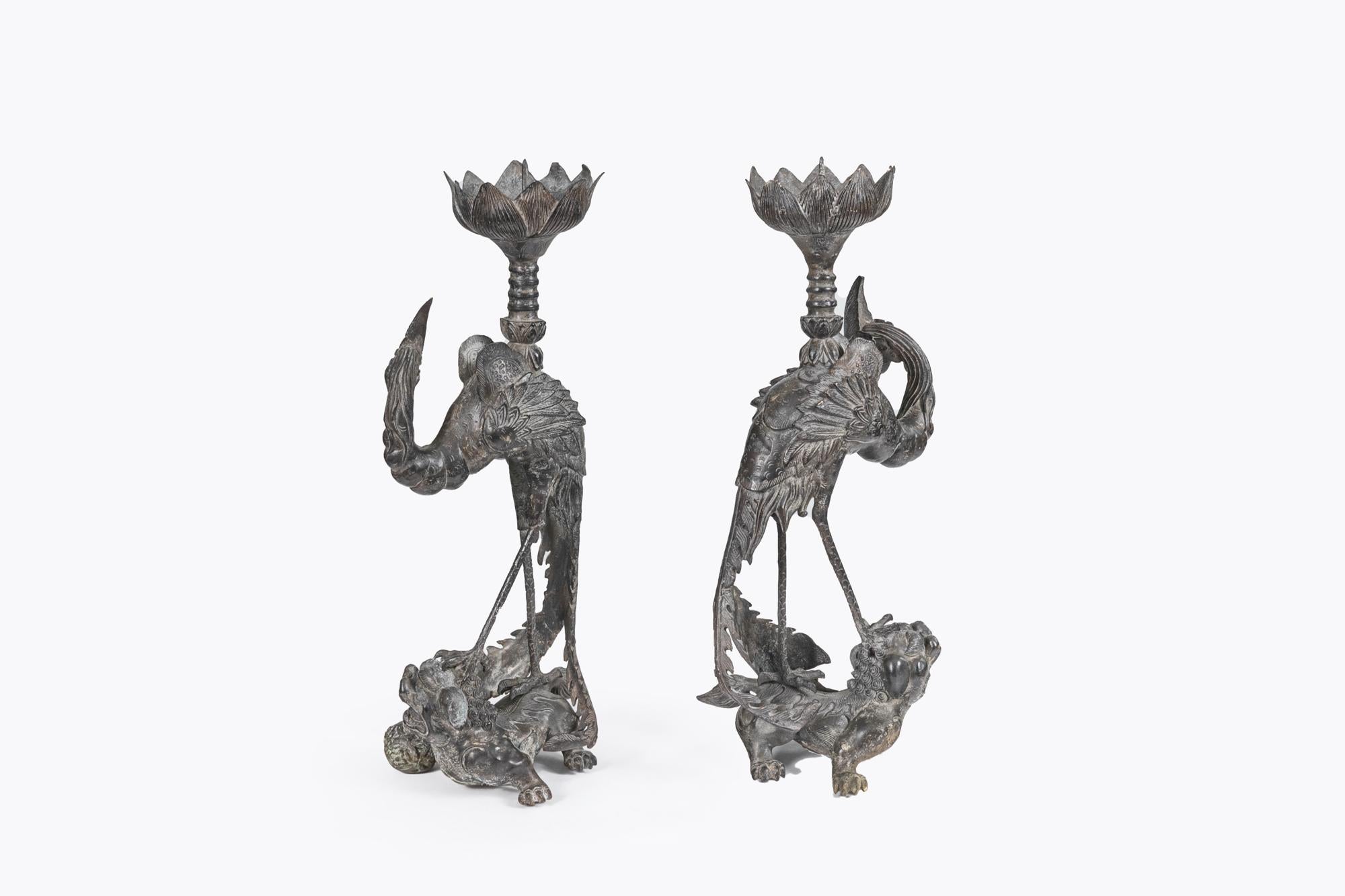 Coppia di portacandele cinesi in bronzo del XIX secolo con gambo a forma di fenice sopra un cane Fu e leccarda a forma di fiore di loto.