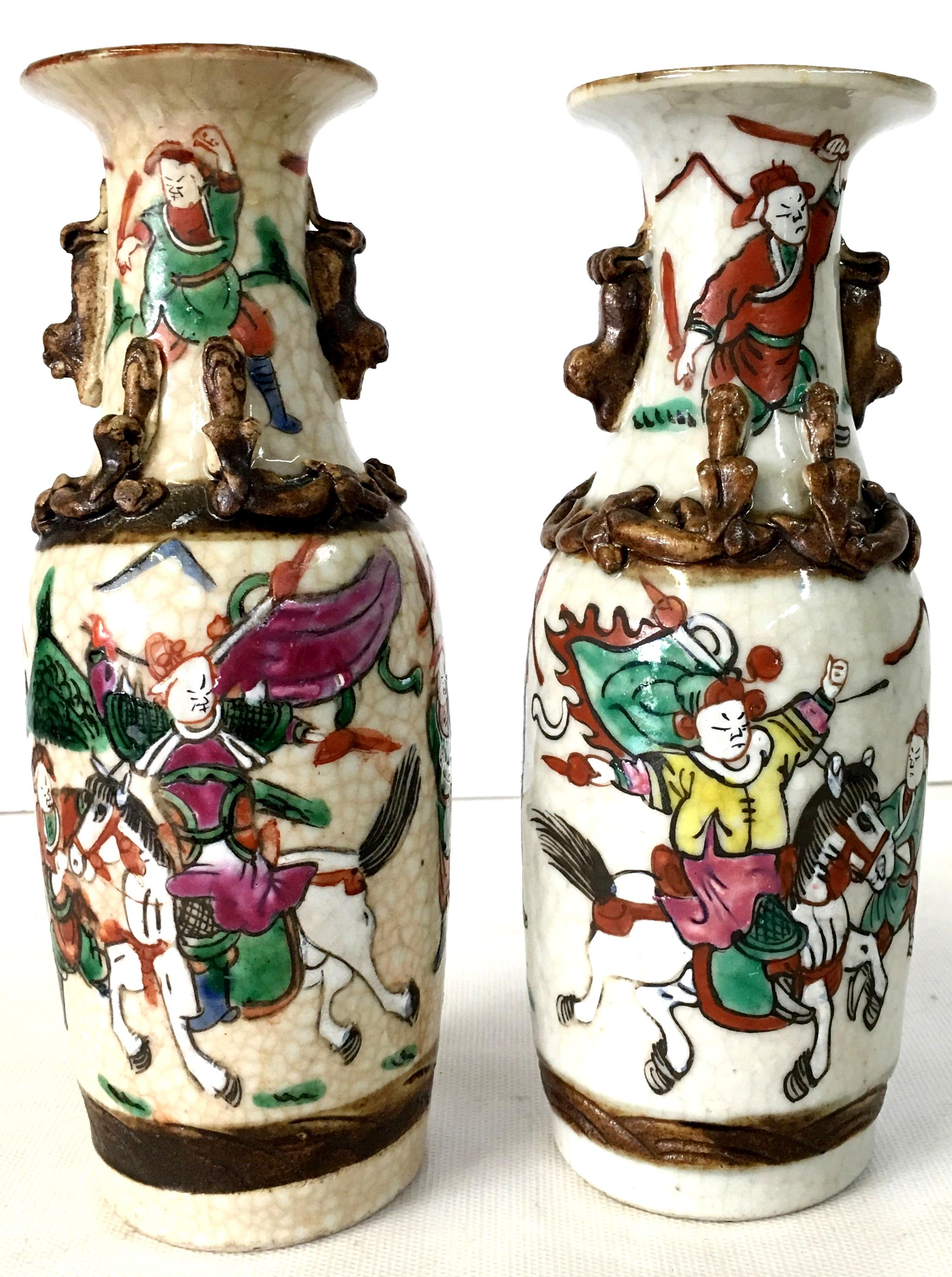 19th Century Antique Japanese Pair Of crackle ware poly chrome warrior motif vases with high relief foo lions. Each piece is signed on the underside and have slight variances.
Hand-painted in purple, green, orange, white, black and blue with brown