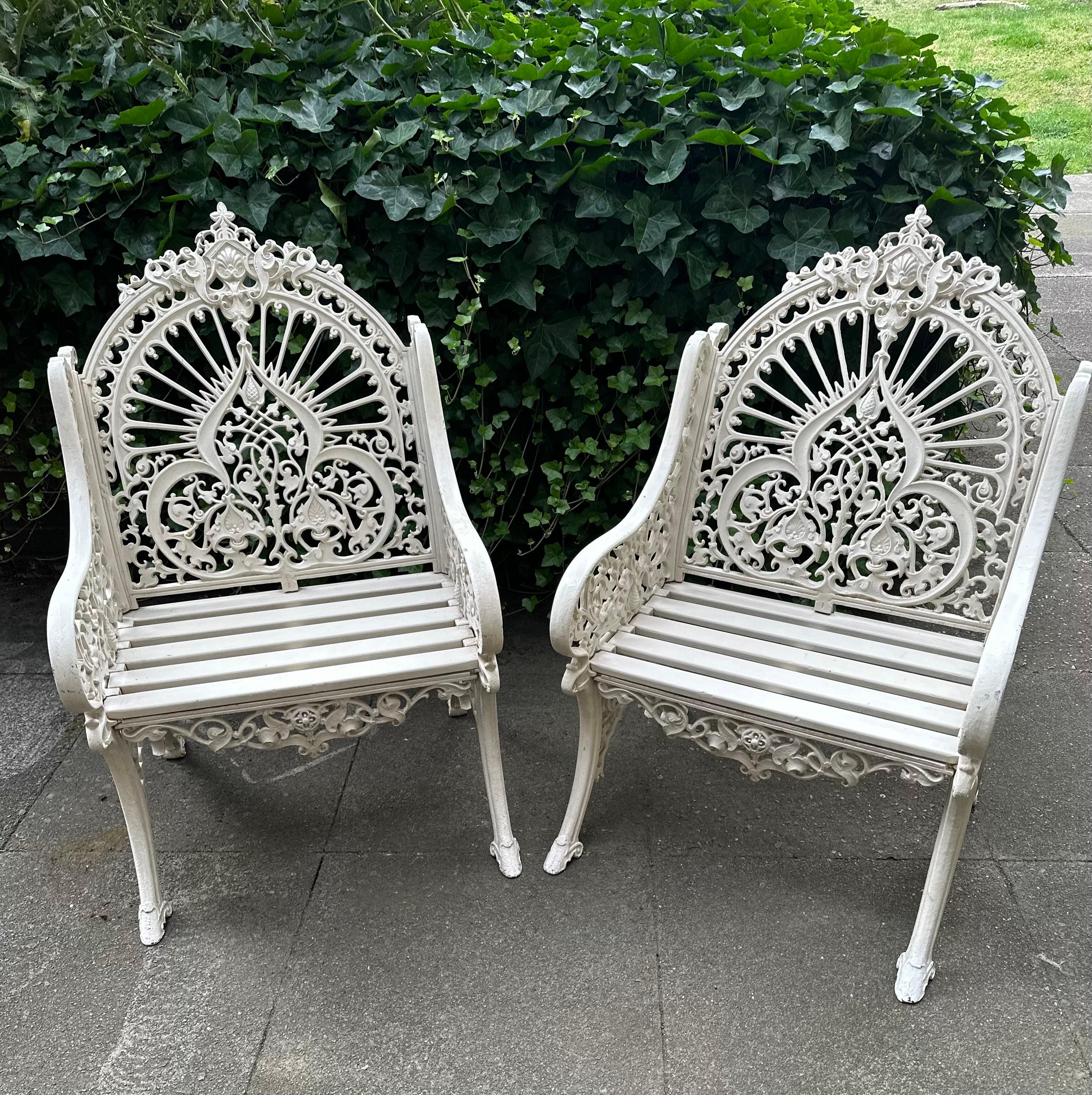 Wonderful and rare pair of original Coalbrookdale chairs made from cast iron with wooden slatted seats and painted white. They have a design mark 90928 first registered in 1853 as “peacock”. 
Extremely elegant and decorative with intricate foliage