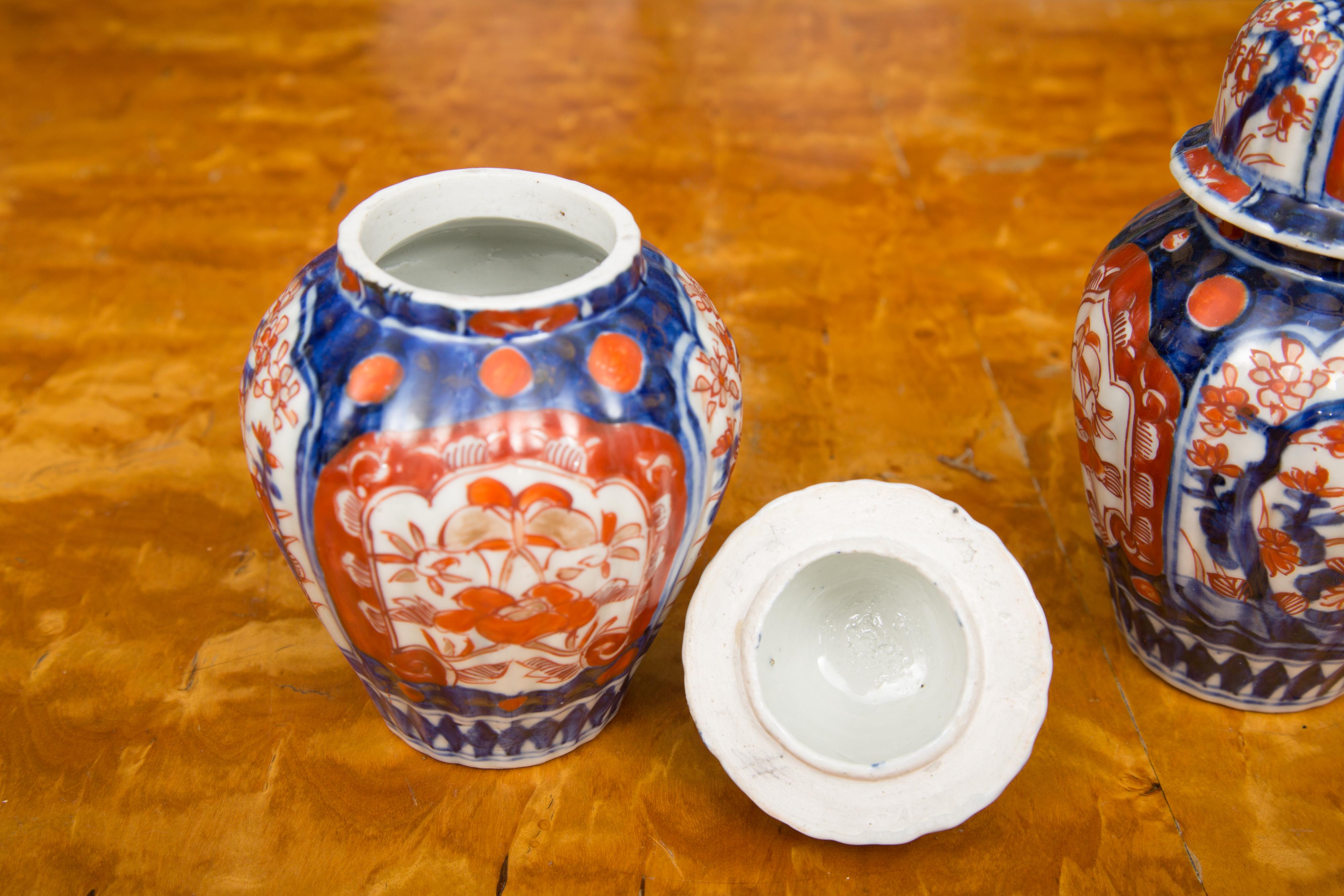 This is a very collectible pair of Classic Imari lidded urns, in traditional colors of cobalt blue and bittersweet orange, circa 1860.