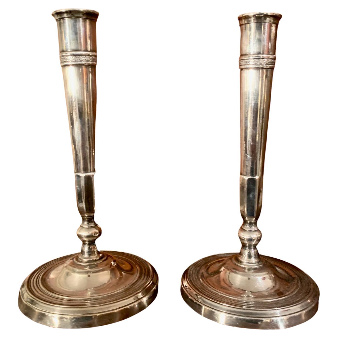 Paar französische Directory-Kerzenhalter, frühes 19. Jh., aus Silberbronze, Sockel mit konzentrischen Bögen verziert, oberer Teil mit kleinem Filigran von Pflanzenmotiven verziert.