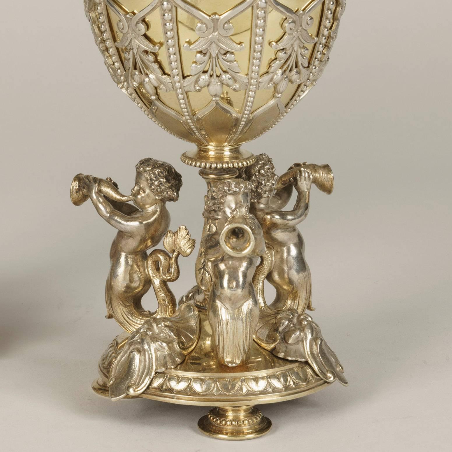 A pair of Elkington & Company lidded confitures

The silver plated vases bear to the underside, Elkington & Co marks, and the date letter for 1873. The circular bases rise on three spun feet, having three tritons blowing on conch shells set about