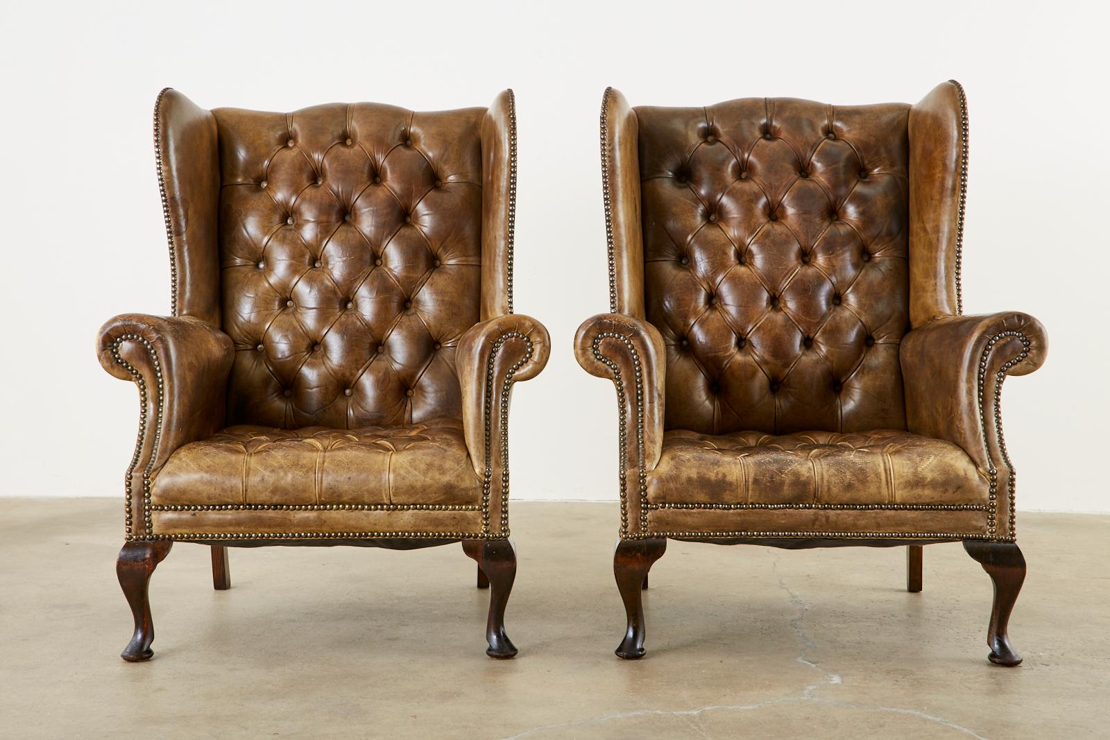 Matched set of 19th century English wingback library armchairs. Featuring a well aged cigar leather tufted upholstery. Handcrafted from hardwood mahogany frames. The chairs weight approximate 55 pounds each and are decorated with brass tack