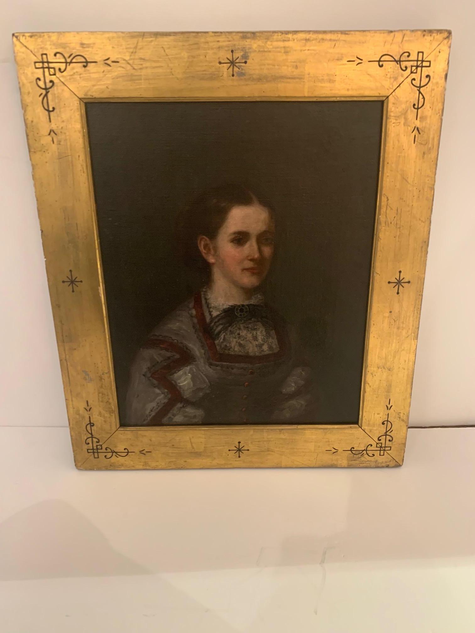 Impressive antique pair of beautifully rendered portraits, moody realism against dark chiaroscuro backgrounds, gorgeously framed in giltwood moldings having simple carved hieroglyphic like decoration.
One portrait is a side view of a child holding