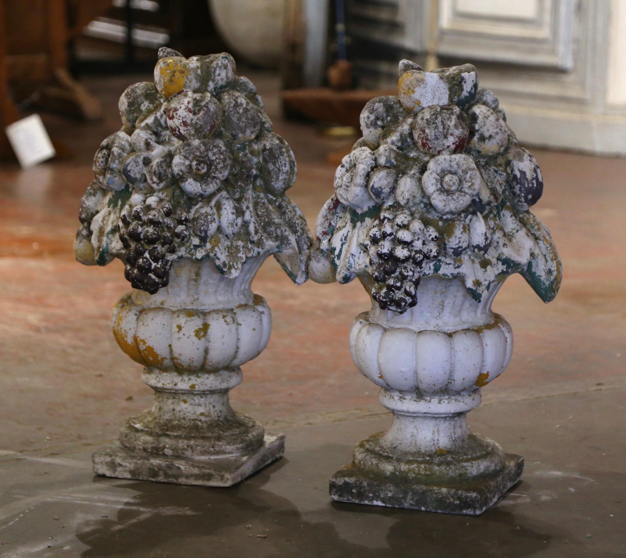 Decorate a patio with this elegant pair of antique outdoor planters filled with fruits and flowers. Carved in France, circa 1880, and built of concrete, each stone jardinière stands on a square base over a short pedestal with a gadrooned shaped