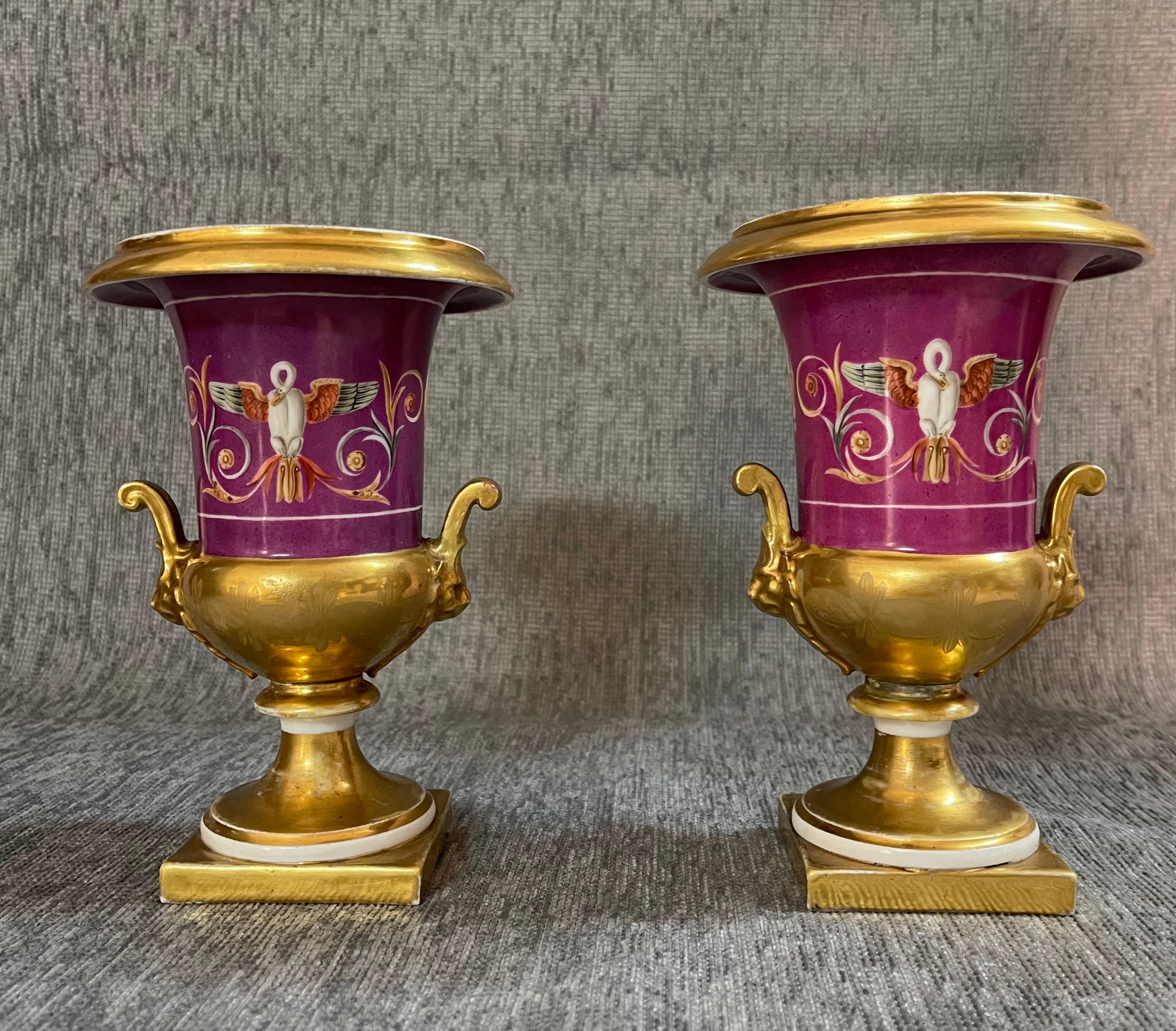 Bellissima e importante coppia di vasi parigini in porcellana Medici dipinti a mano.
Presentano eleganti motivi neoclassici sul corpo: cigni ad ali spiegate e panoplie.
Le maniglie superiori, inferiori e laterali sono tutte dorate in oro