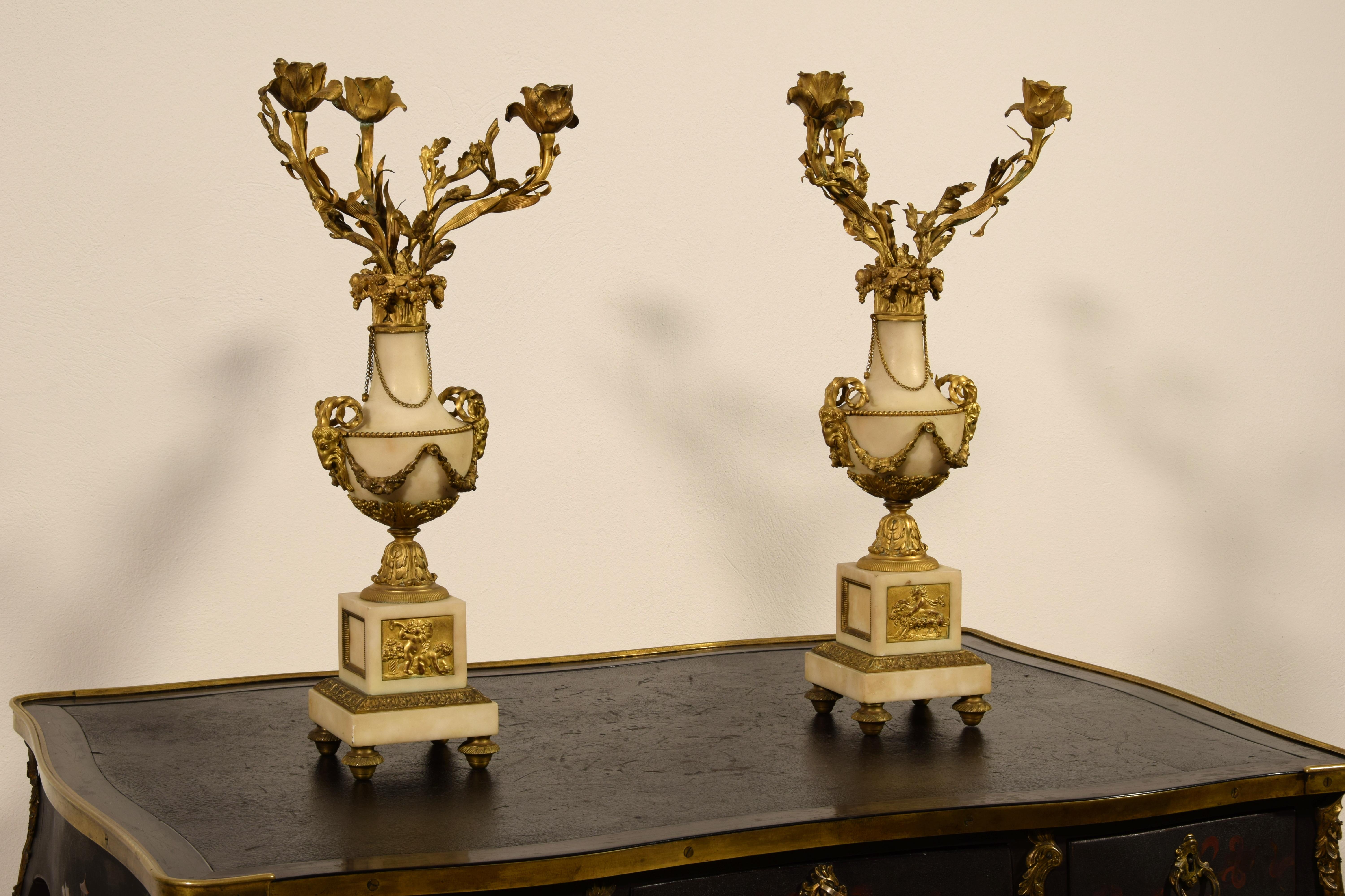19th century, pair of French gilt bronze and marble candelabra

The pair of three-light candelabra was made in the 19th century in France in the Louis XVI style.
Each candelabra consists of a central part in white marble in the shape of a vase