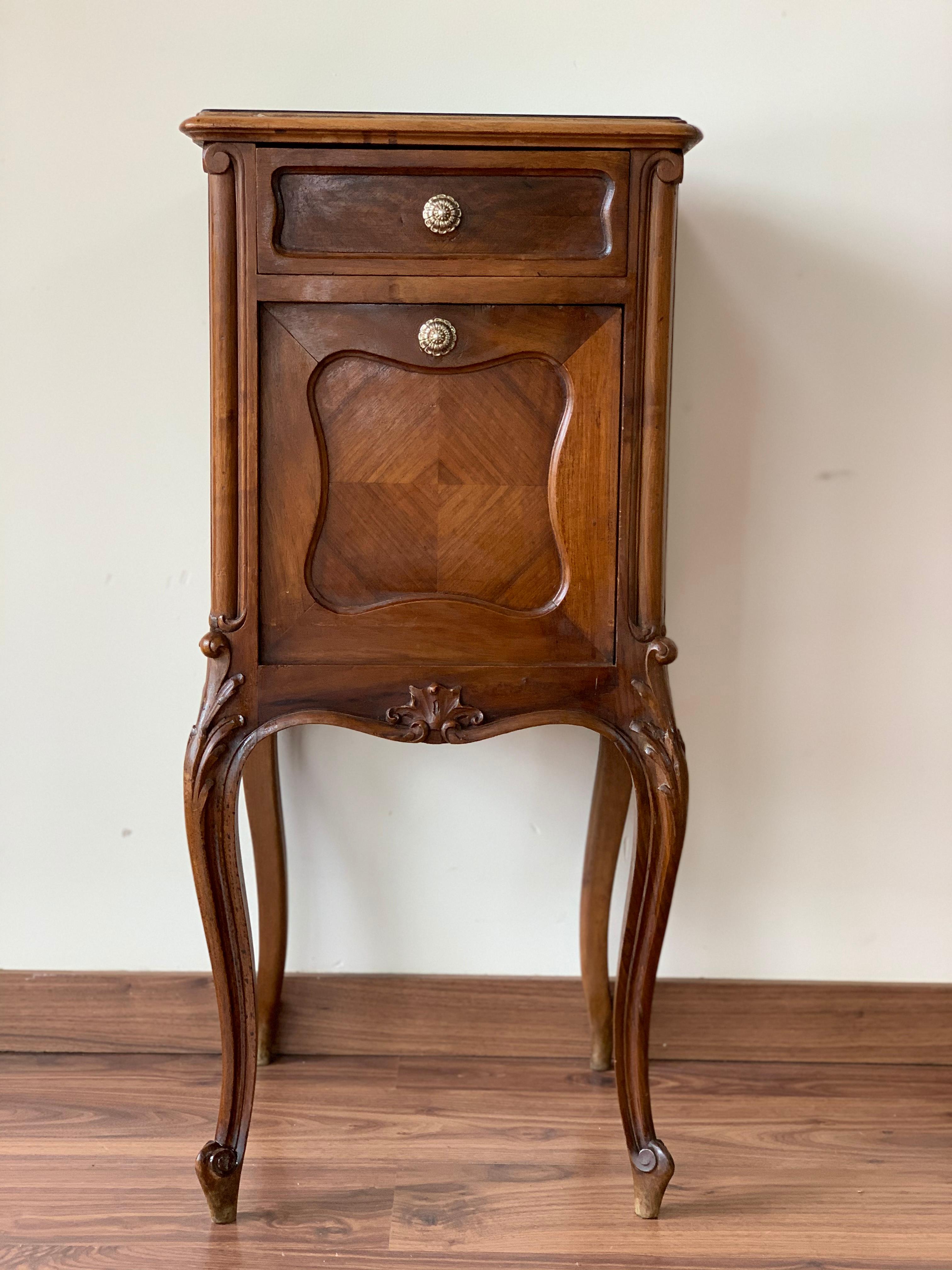 19th century pair of Louis XV carved nightstand with one drawer and black glass top. The nightstands have one drawer and fronts fold down to reveal a storage compartments with marble base.