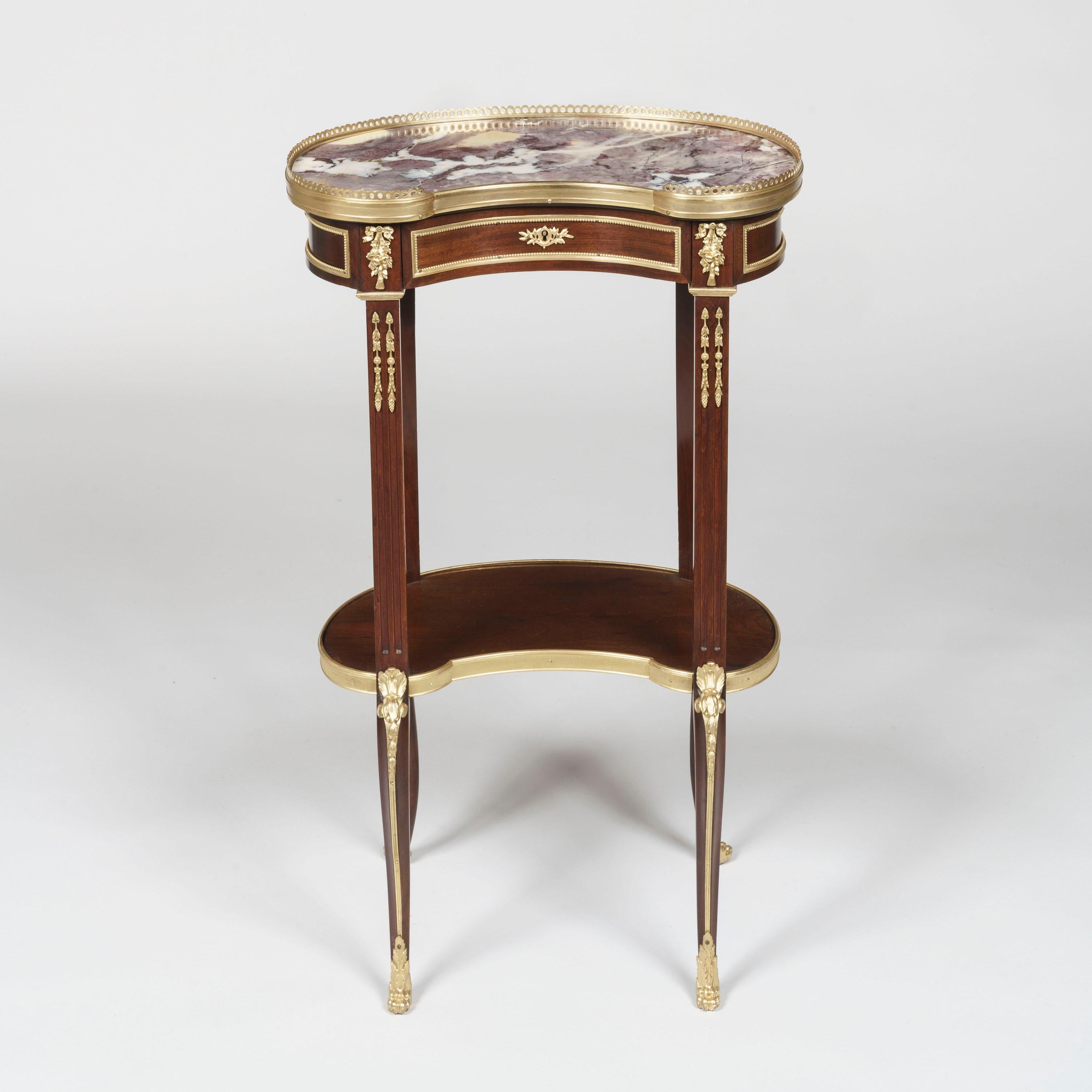 A pair of ormolu-mounted tables Ambulates
In the transitional style

The tables of kidney-shape and veneered with fine mahogany, supported on cabriole legs with lion's paw sabots and ormolu espagnolettes joined together by a shaped undertier, the
