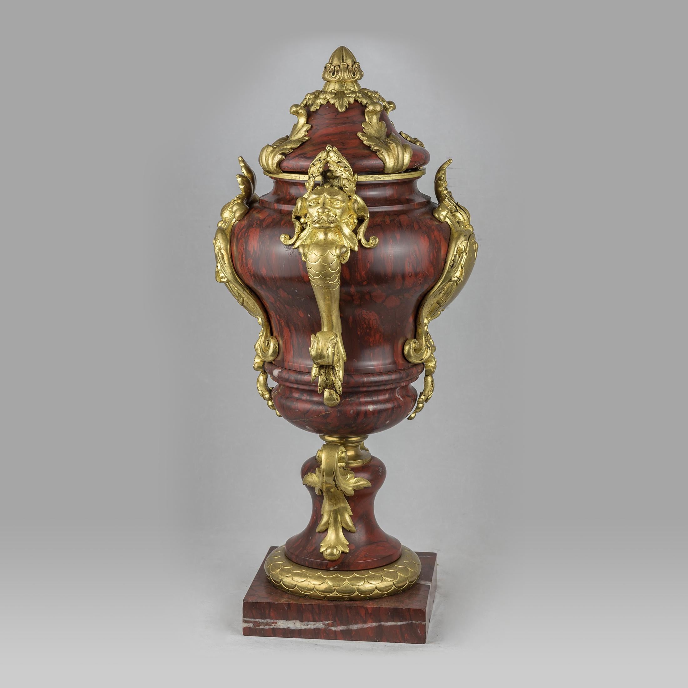 A pair of fine quality French ormolu-mounted rouge marble urns and cover, each with a bulbous body on a stepped plinth 

Origin: French
Date: 19th century
Dimension: 19 in x 9 in.