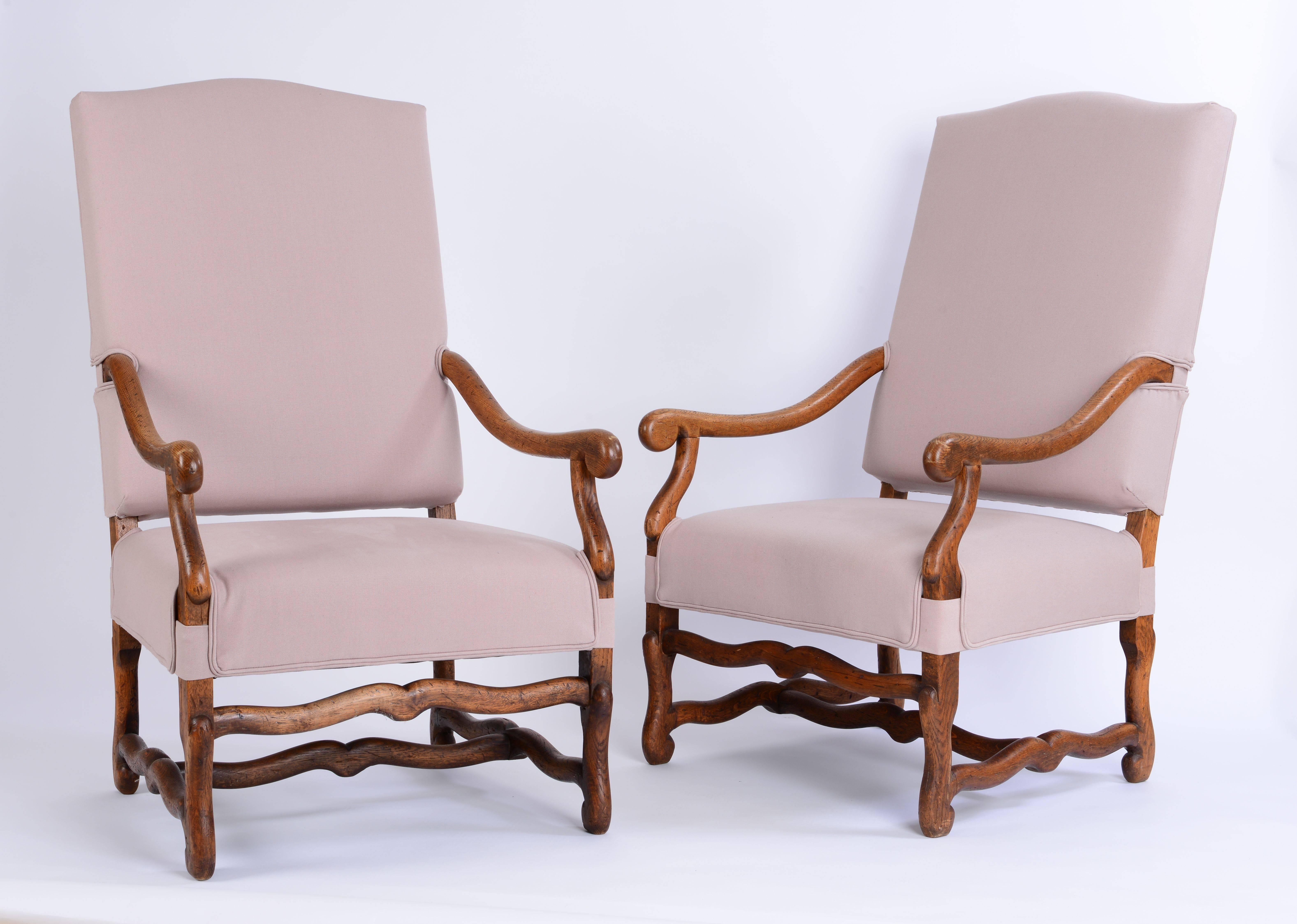 Essential for a touch of Belgian style the Os de Mouton armchair. This beautiful large pair in oak has a lovely patina, is very heavy and sturdy and extremely comfortable. Recently reupholstered by us in pinkish, incredibly soft Belgian