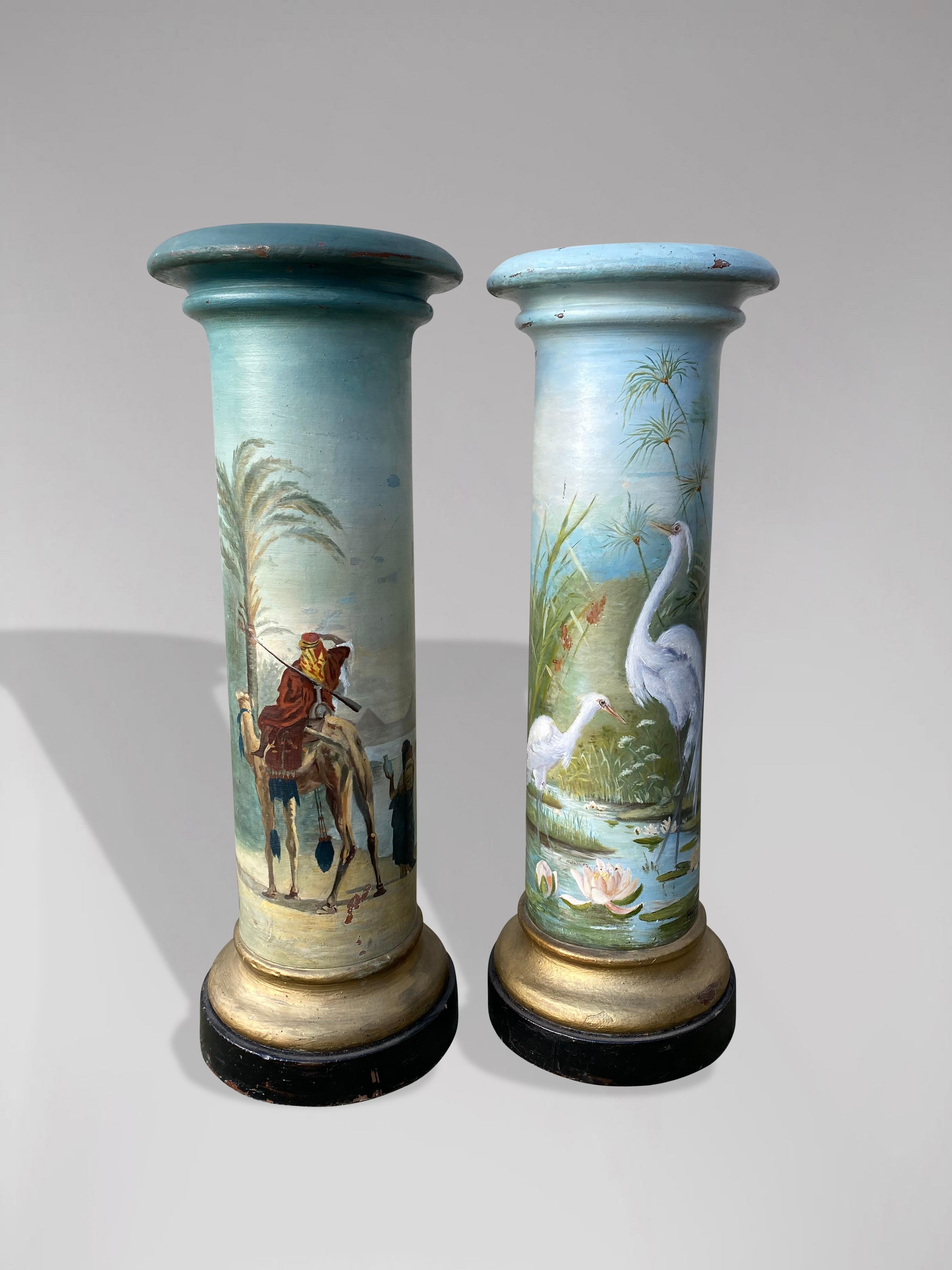 A stunning pair of columns or a pair of terracotta stands painted with an oriental scene on one and a Japanese scene with two cranes in a pond and water lilies on the other. French work, late 19th-early 20th centuries. These decorative columns were