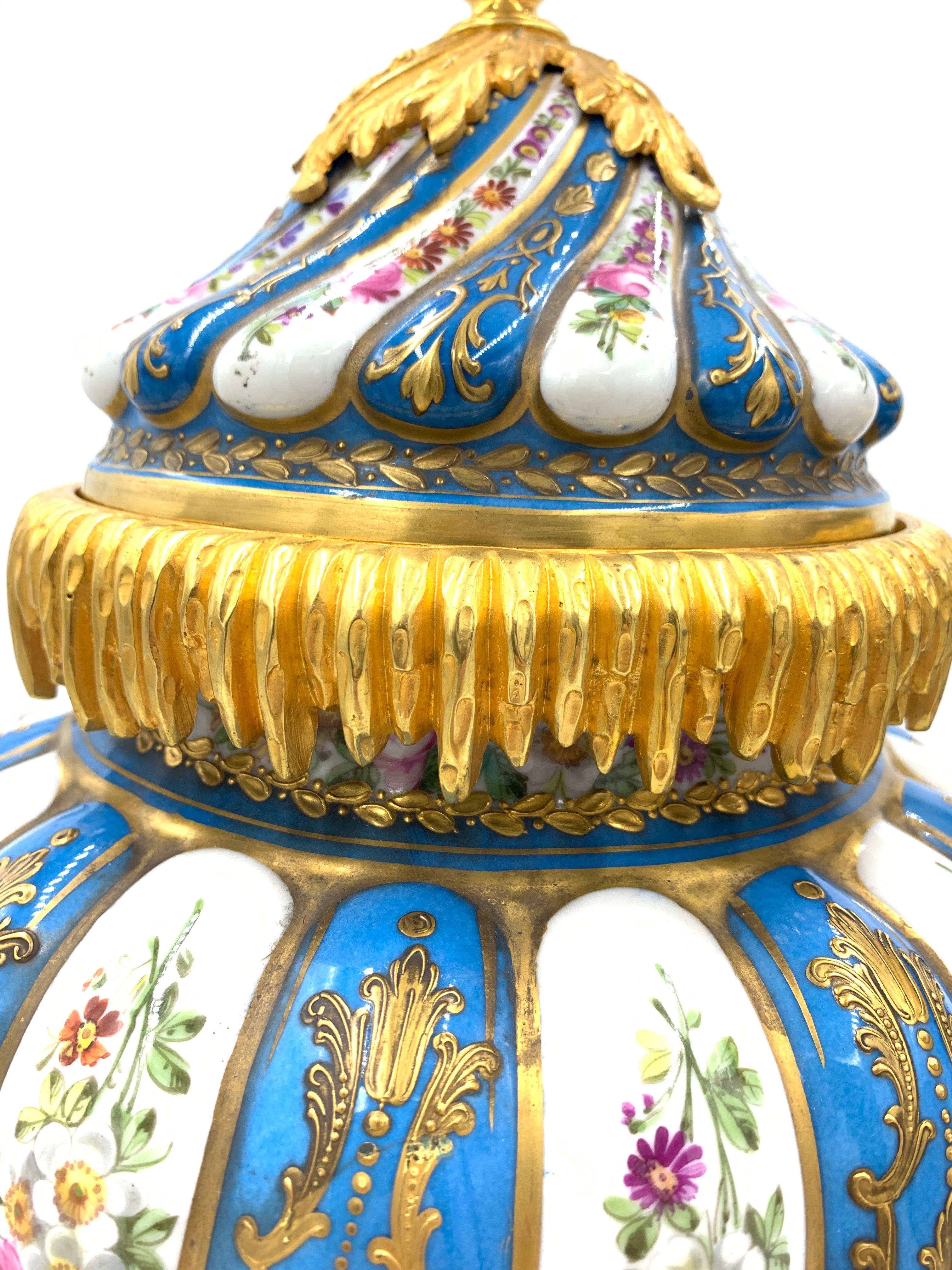 A beautiful pair of turquoise sevres style vases, unique twisted shape with a floral design and gilded ormolu mounts all around the vases.
   