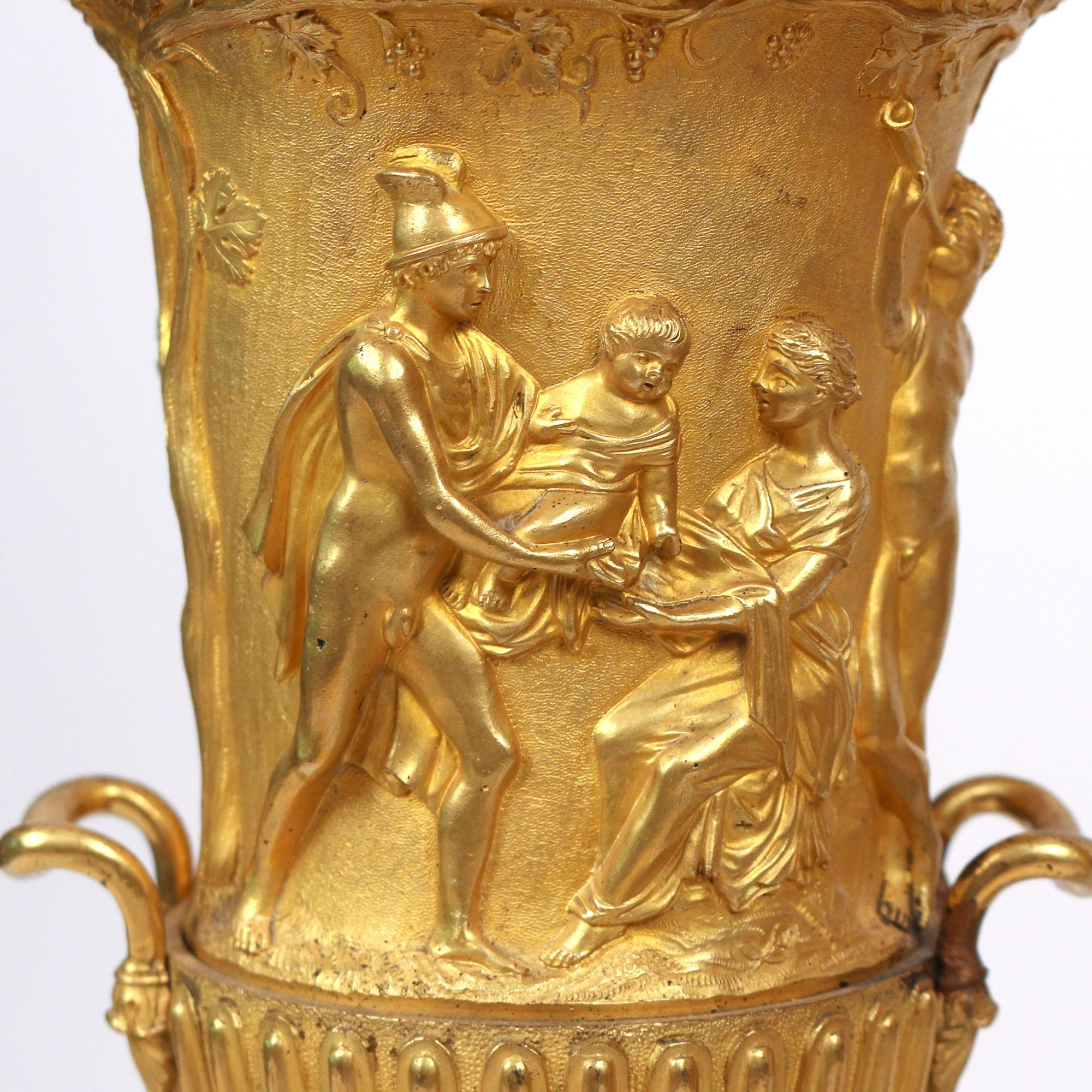 A Fine quality pair of gilt bronze neoclassical urns. 
The campagna form showing figures engaged in various activities and mounted on black onyx plinths.

Origin: French. Date: 19th century. Size: 17 1/4 in. x 6 1/2 in.
