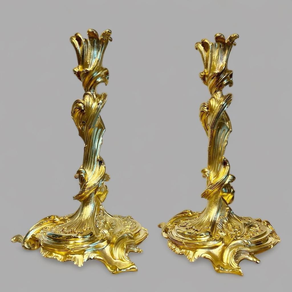 Wir präsentieren Ihnen dieses prächtige Paar vergoldeter Bronzeleuchter aus dem frühen 19. Jahrhundert, das sich an einem Modell des berühmten französischen Goldschmieds, Malers, Bildhauers und Architekten Juste-Aurèle Meissonnier (1695-1759)