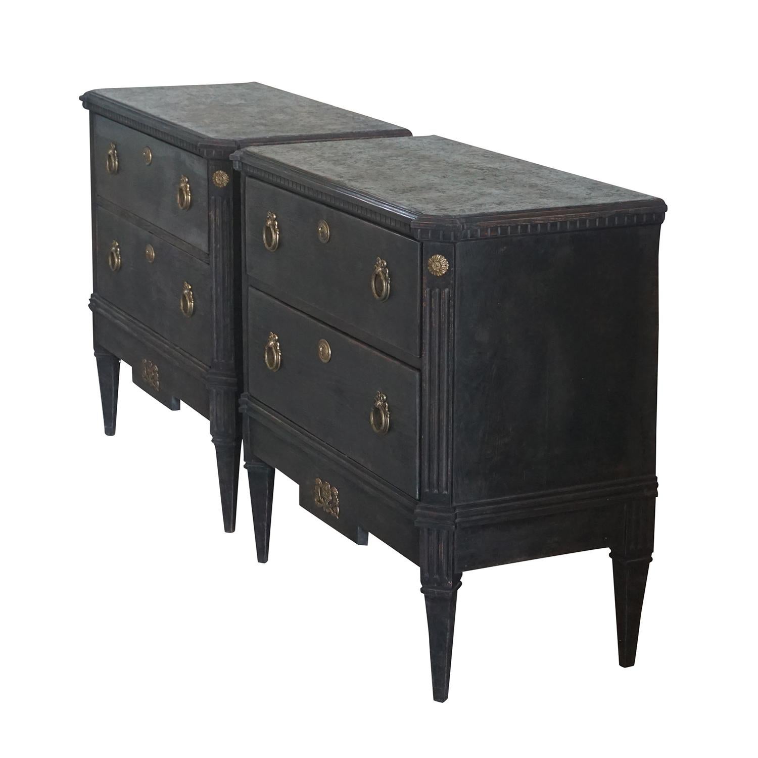 An antique Swedish Gustavian, ornate neoclassical pair of black chest of drawers with faux marble, hand painted tops and original brass locks. The Scandinavian commodes are in good condition. Wear consistent with age and use, circa 1830-1850,