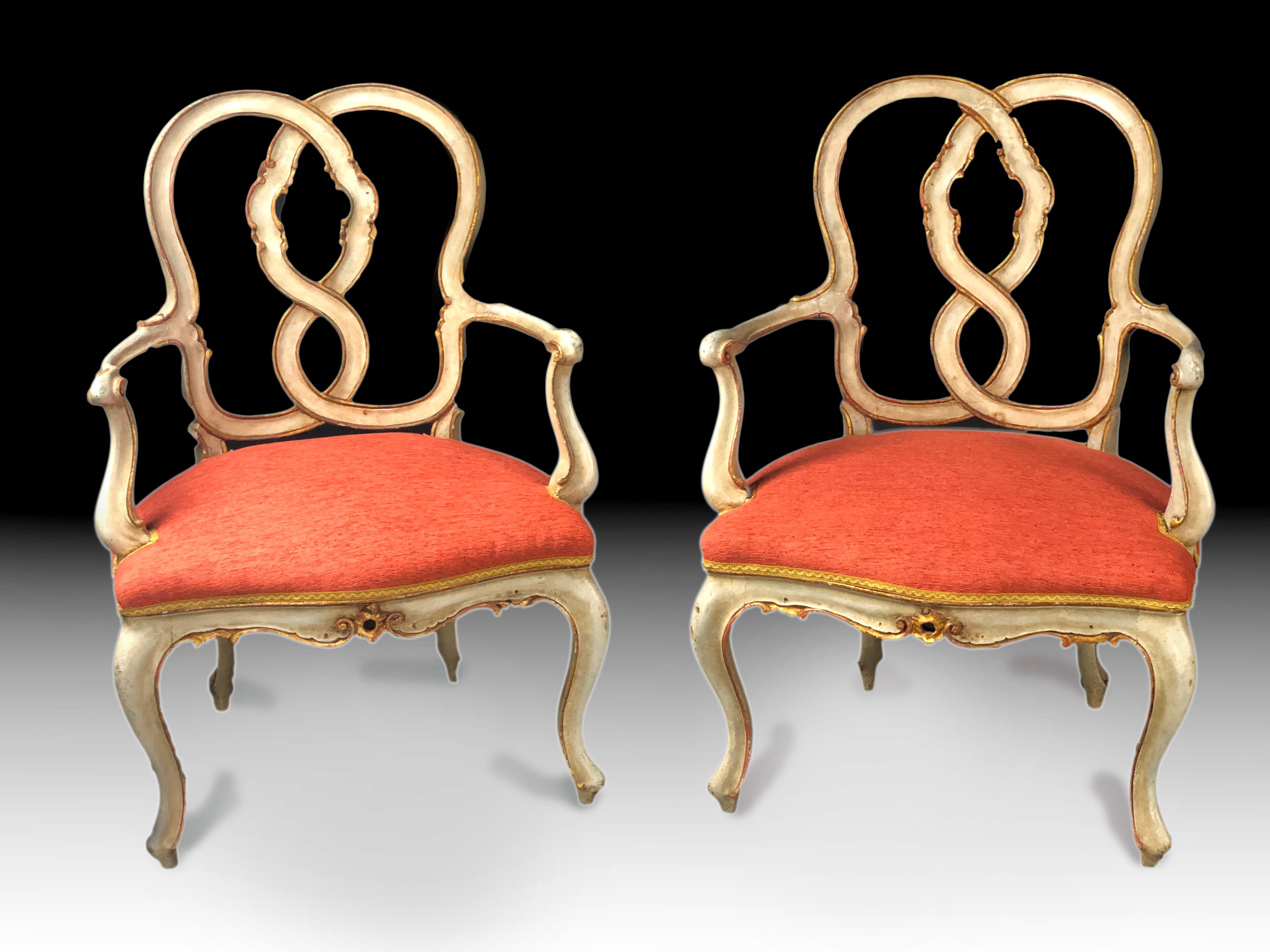 Impressive and rare pair of early 19th century Italian armchairs, most probably Venetian, painted in their original light grey color, parcel gilt and with original patina and wear through their 2 centuries of existence. Their back with interlaced