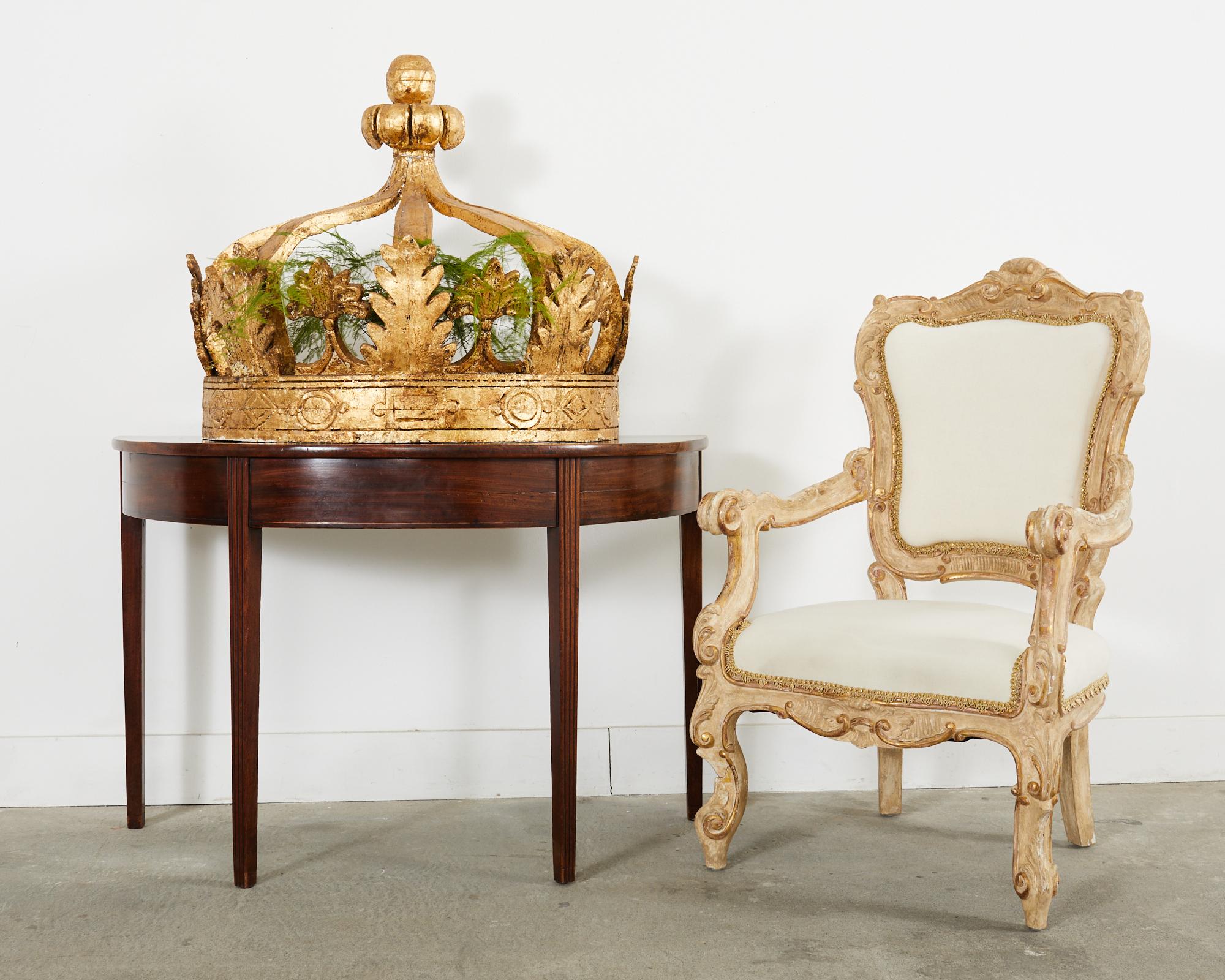 Dramatic pair of large 19th century Italian bed coronas or crowns made in the Baroque taste. The coronas feature demi-lune shaped frames embellished with gold leaf and decorated with delicate acanthus leaves and stylized fleur de lis motifs. The